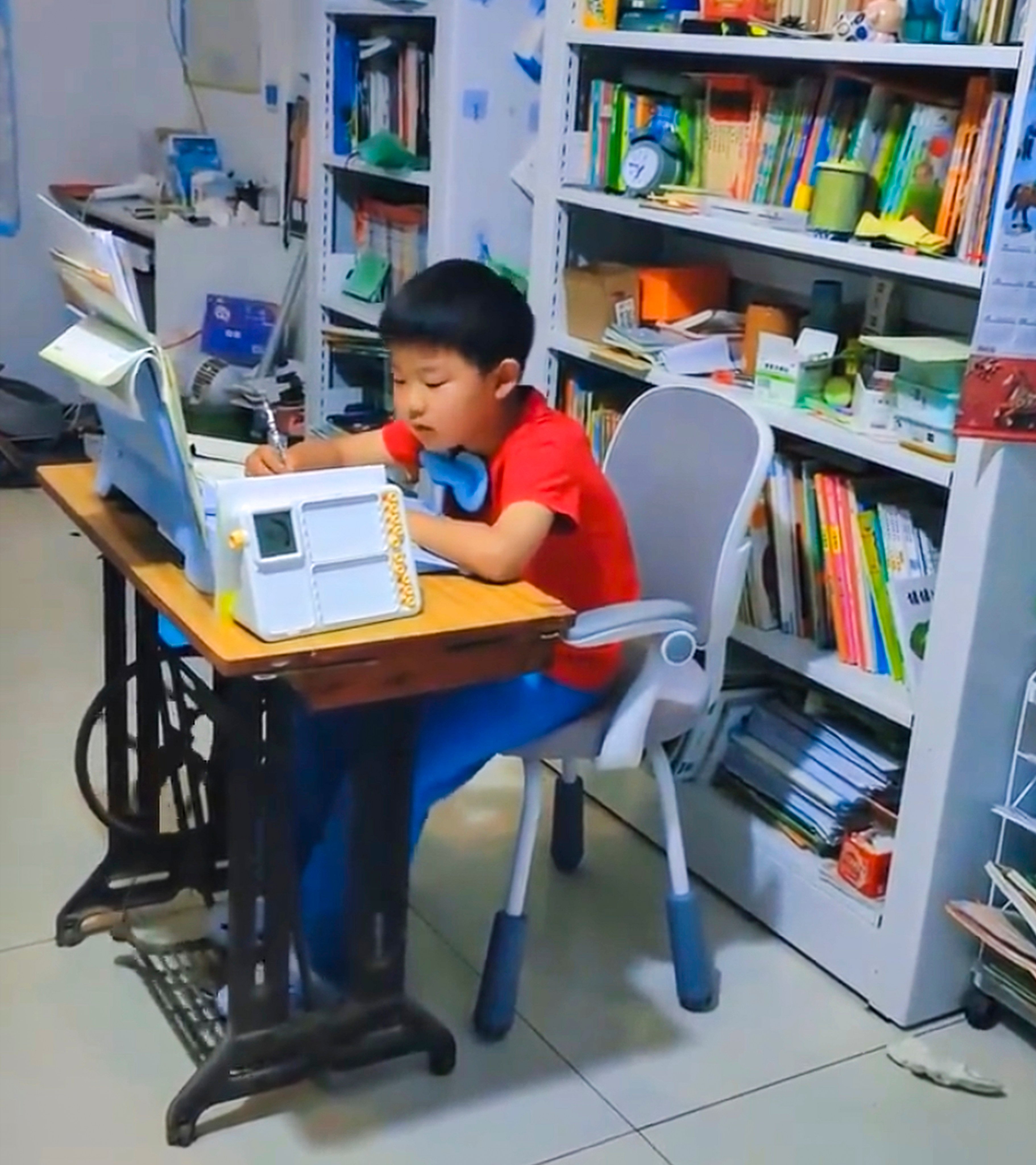A mother in China has improved her son’s focus while he is doing homework by having him peddle a sewing machine as he works. Photo: Weibo