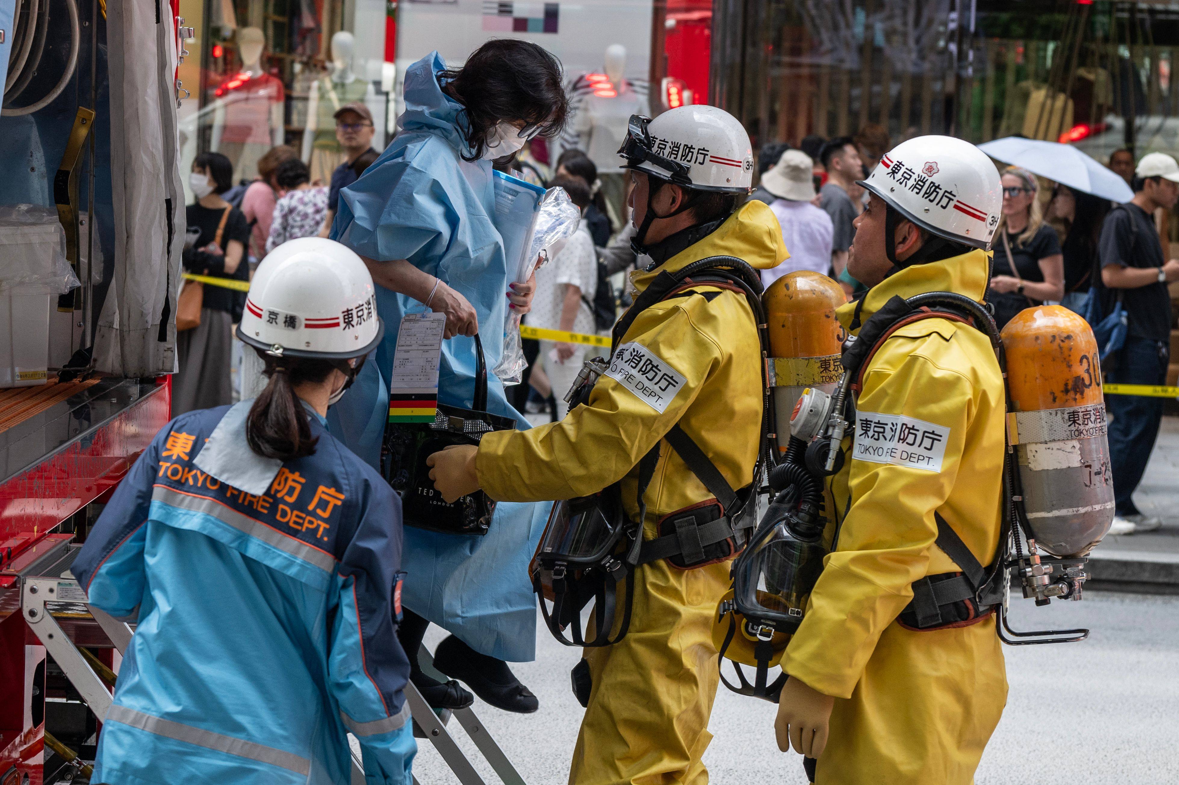 Emergency personnel help a woman who was inside the Ginza Six Shopping Centre on Monday. Photo:  AFP