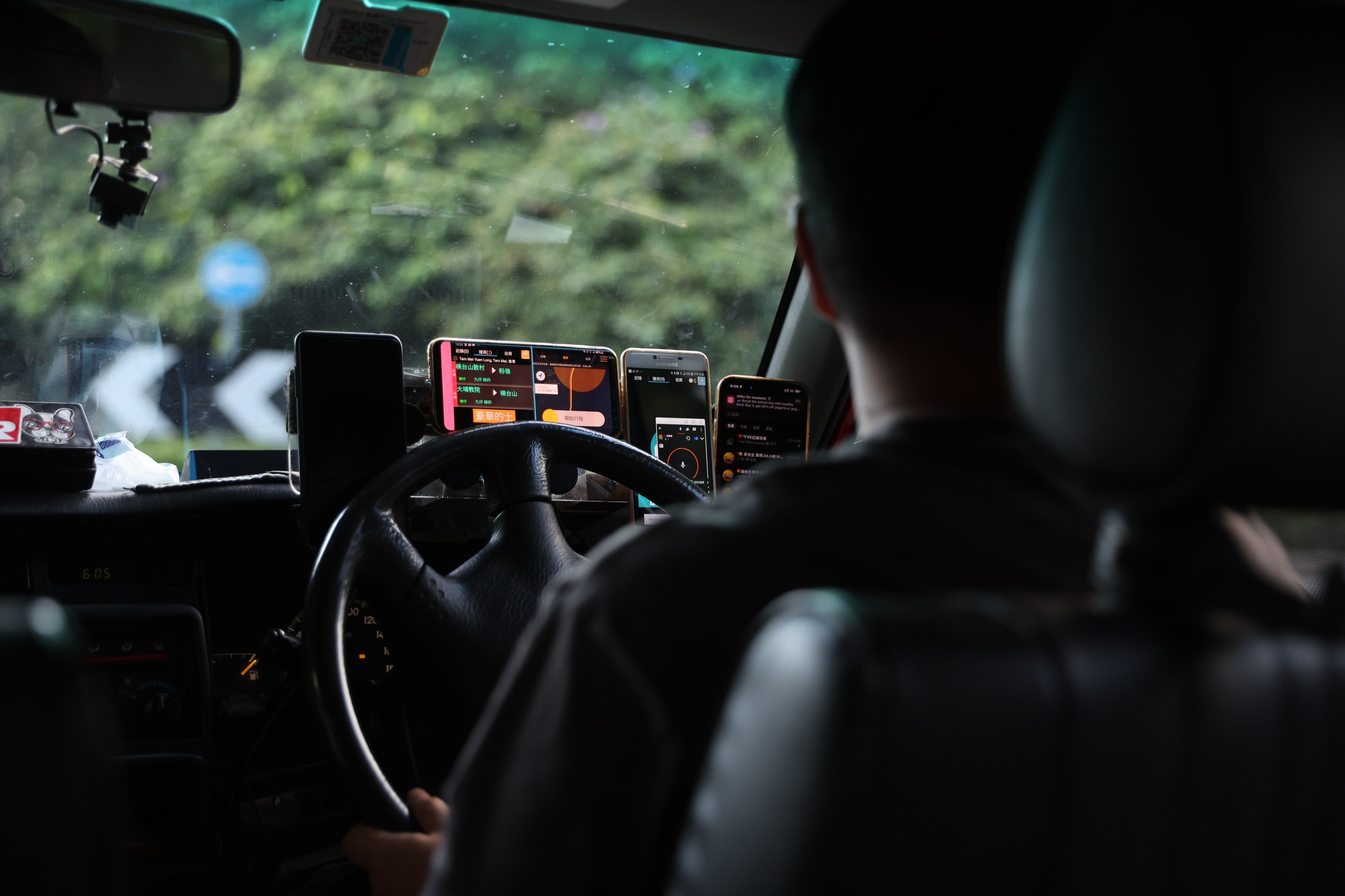 A dashboard is lined with mobile phones for ride-hailing apps on September 2, 2025. Photo: Edmond So