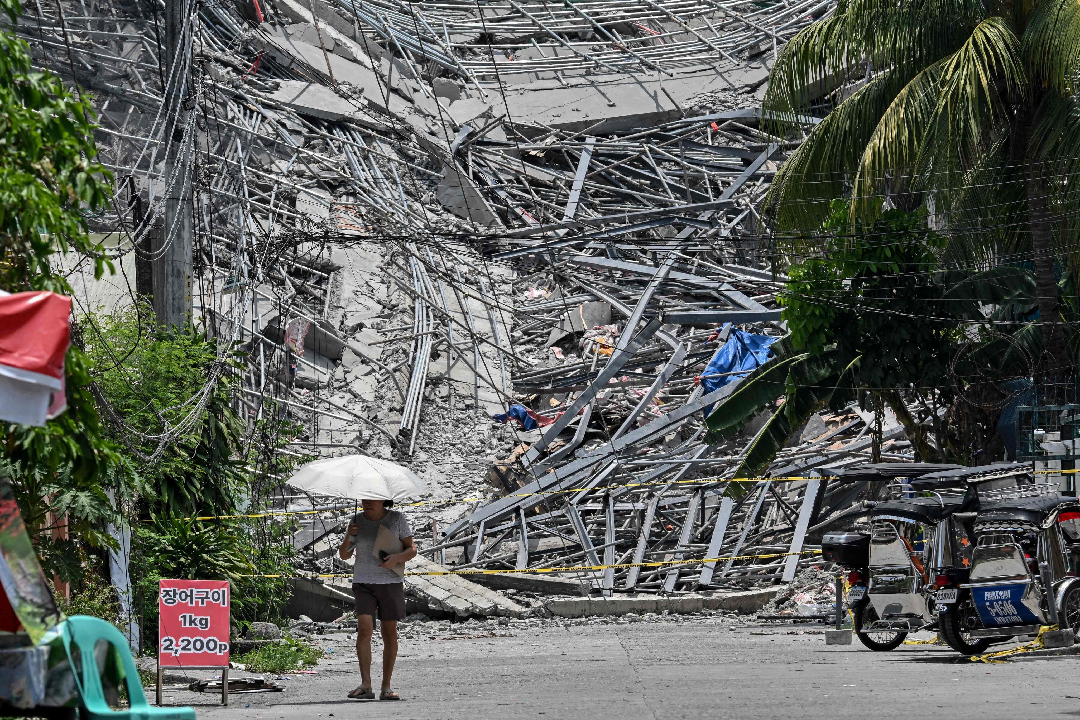 A resident walks past the rubble of a collapsed building in Angeles City, the Philippines, on Monday. Photo: AFP