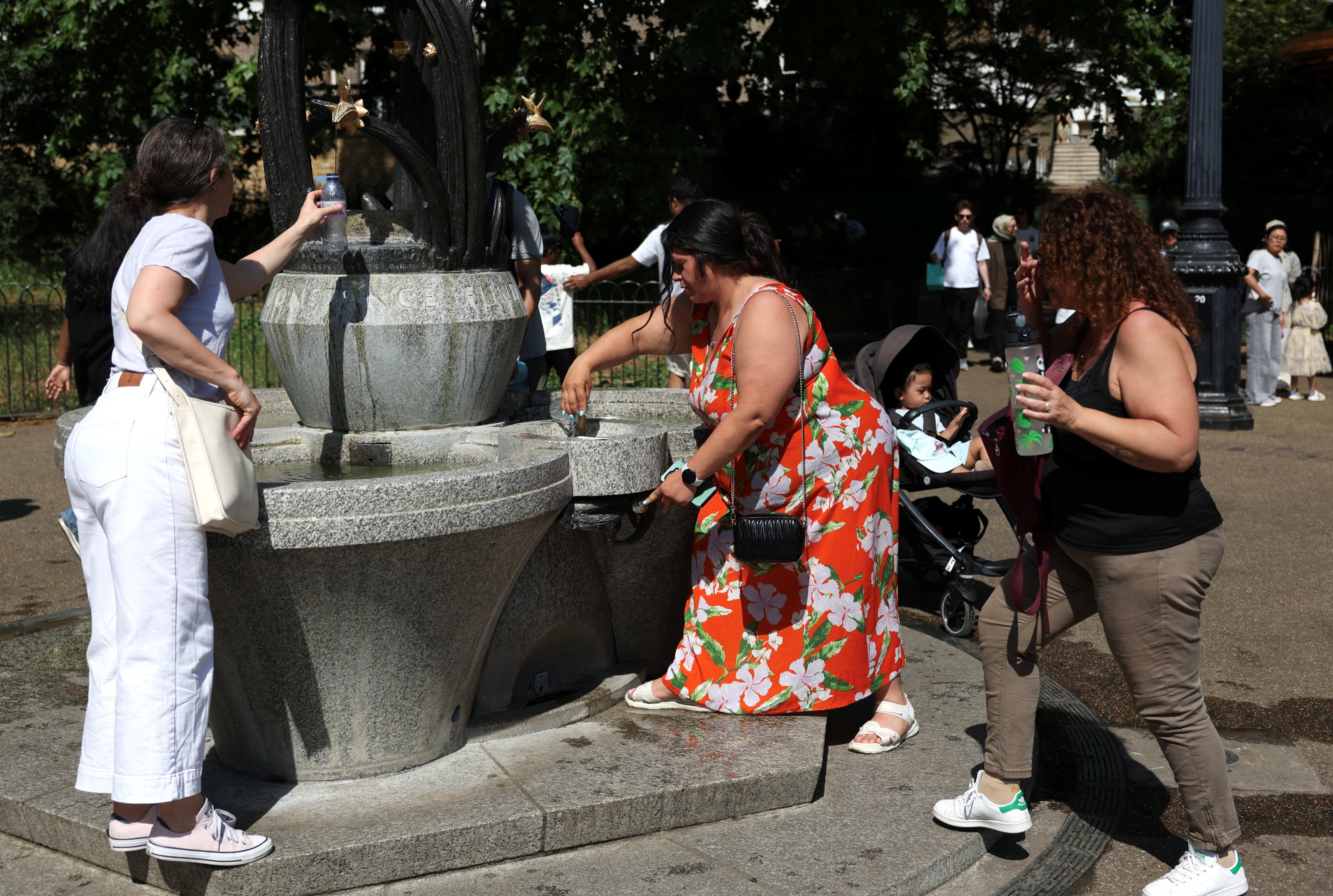 People refill their water bottles from a fountain in Green Park, London, during a heatwave on Monday. Photo: Reuters