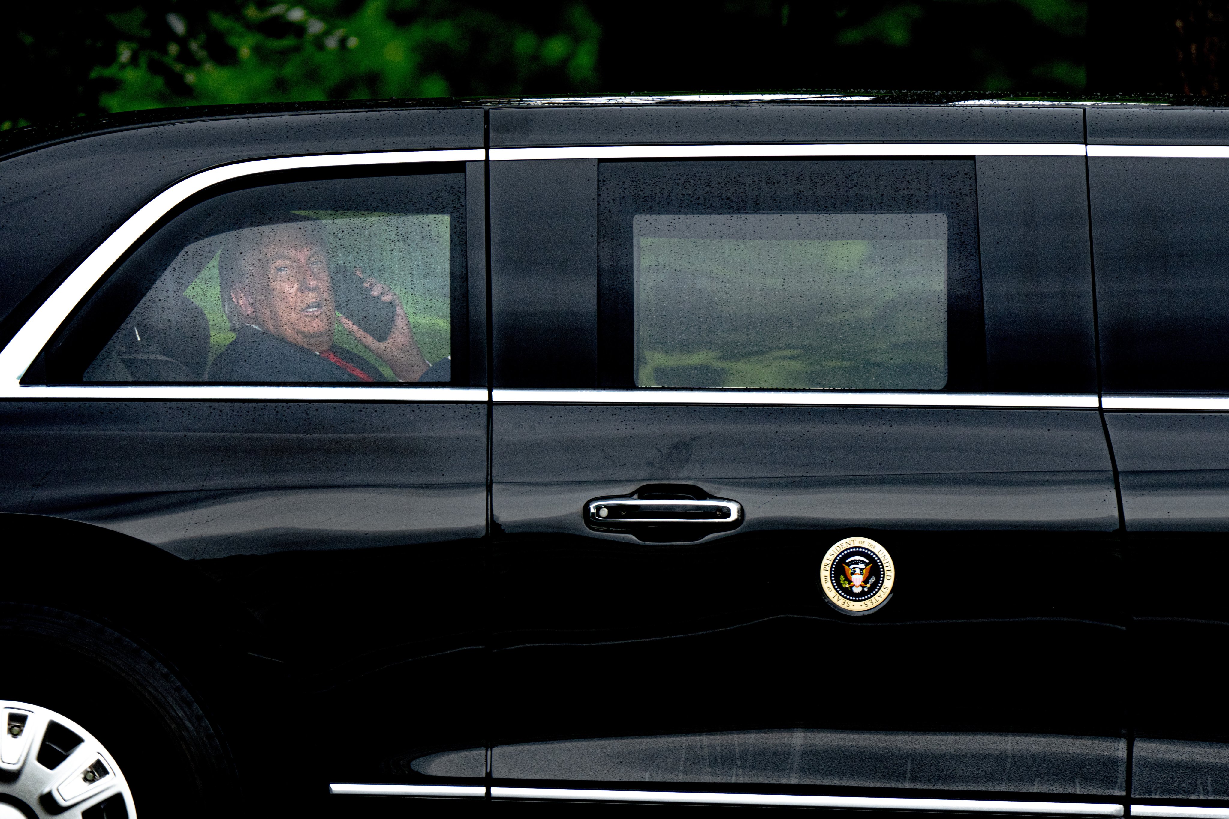 US President Donald Trump speaks on the phone inside his limousine on Monday. Photo: EPA