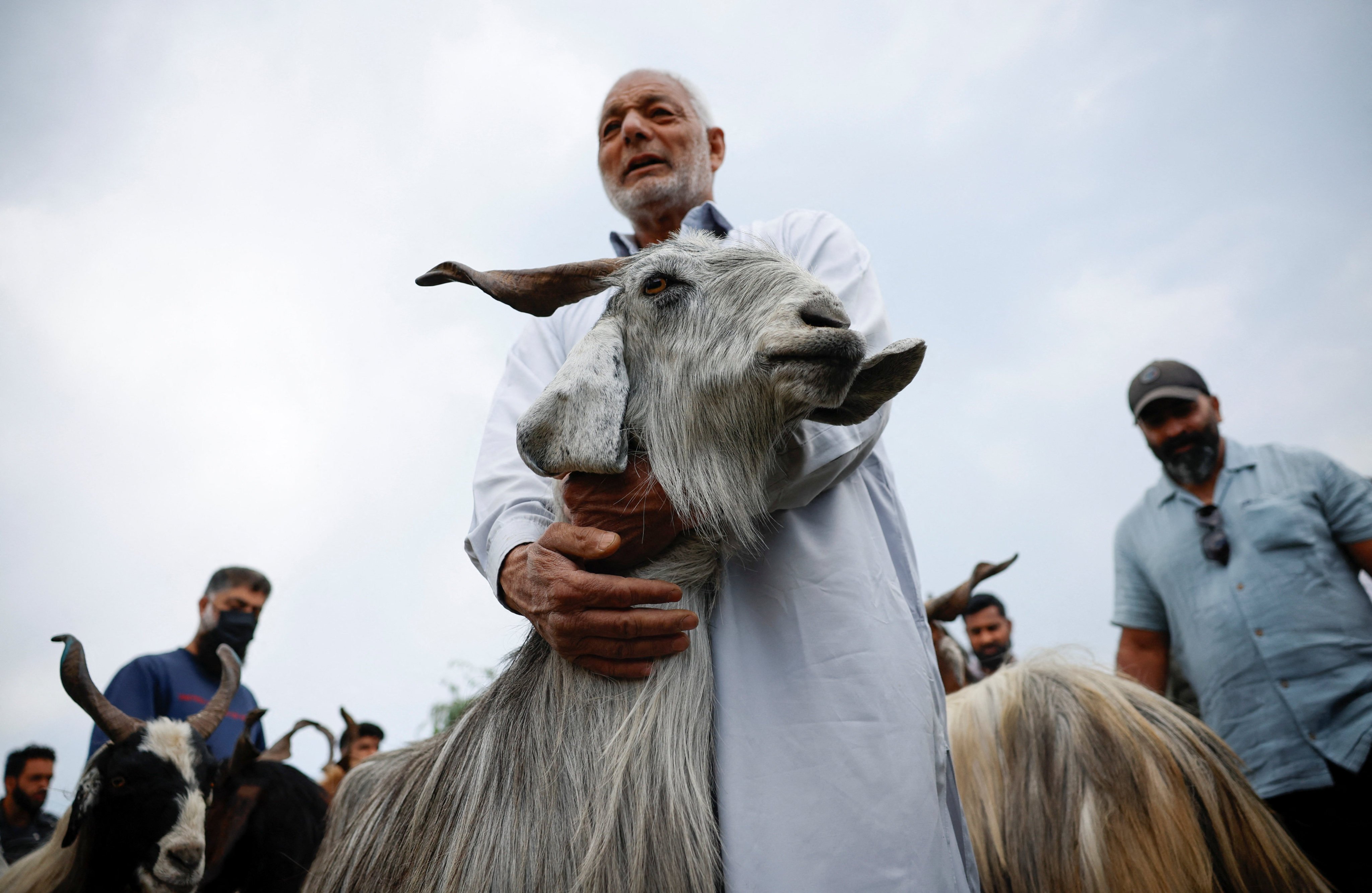 A Kashmiri man holds a goat after buying it at a livestock market ahead of the Eid al-Adha festival in Srinagar, Indian Kashmir, May 25, 2026. REUTERS/Sharafat Ali