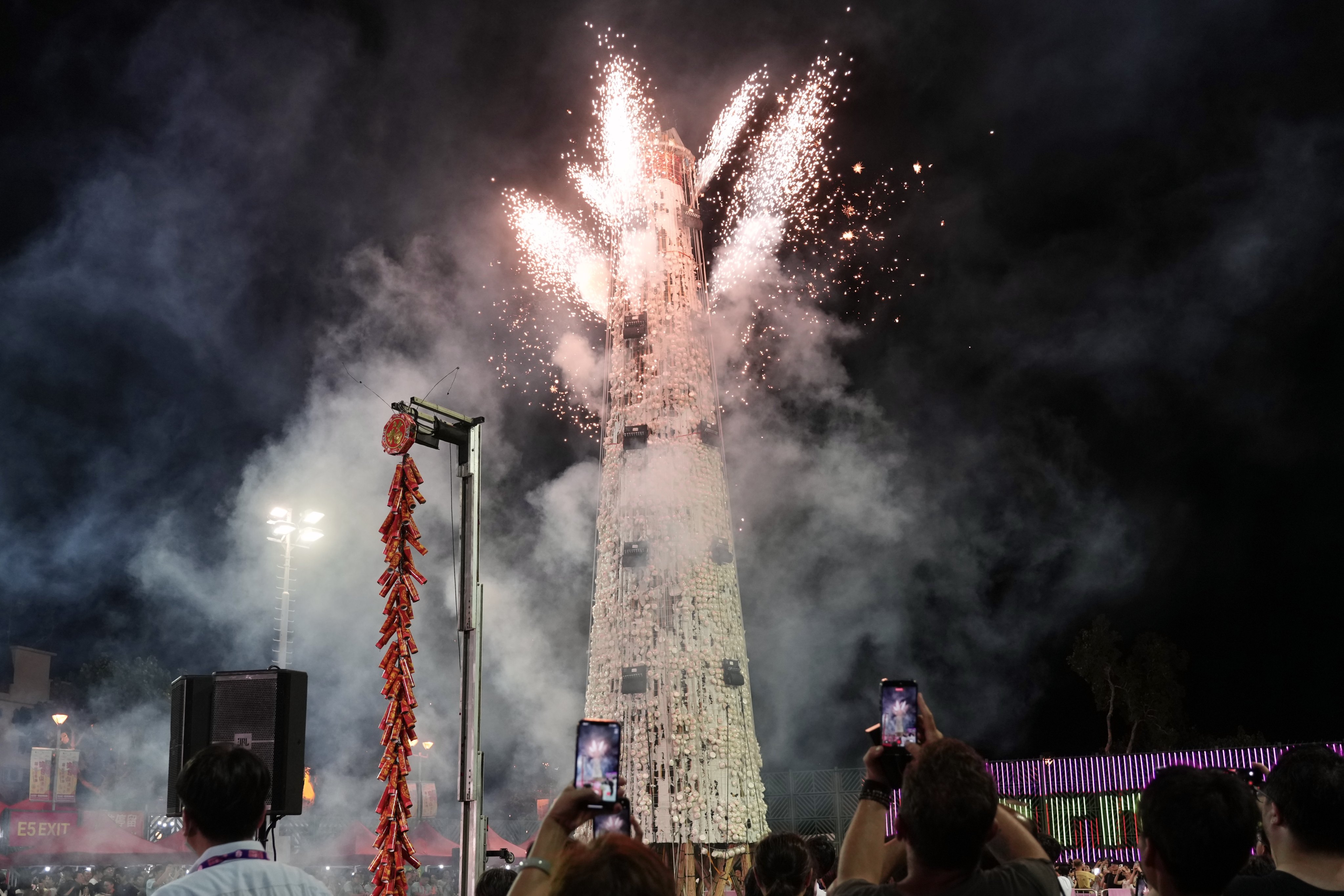 Spectators take photos as fireworks sparkle after the bun scrambling competition final at the annual Bun Festival in Cheung Chau on May 24. Photo: Karma Lo