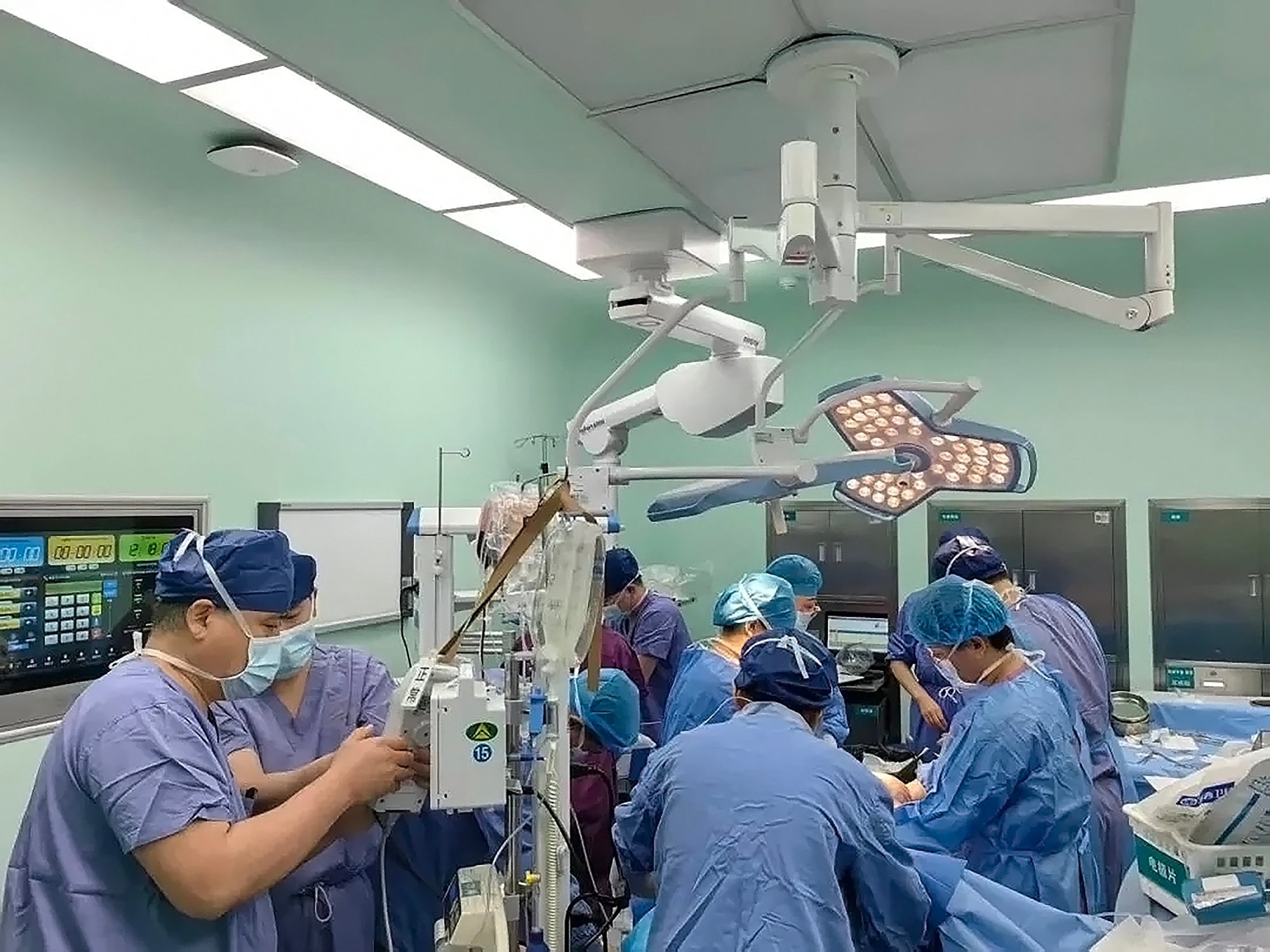 Surgeons, above, performing surgery on the woman who arrived at the hospital soaked in blood. Photo: Weixin