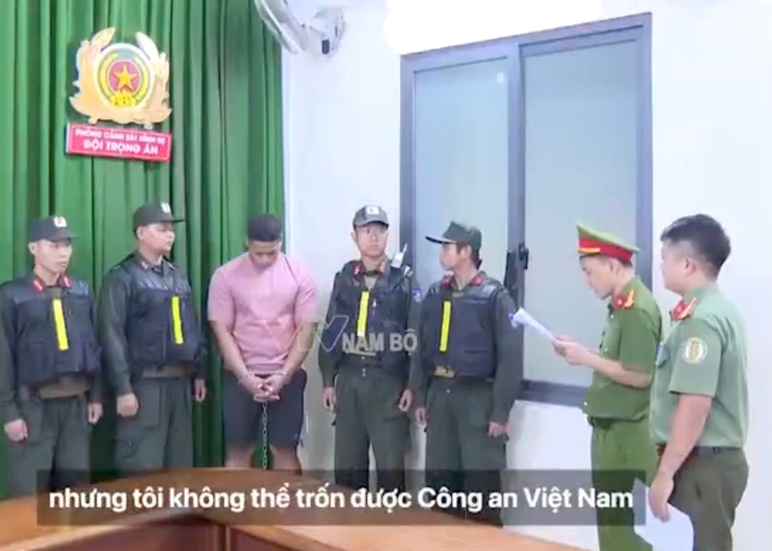 Steve Tafia, a Samoan suspect who is accused of the gun killing of an Australian gangster in Ho Chi Minh City, stands alongside Vietnamese police officers. Photo: X/Jacob in Cambodia