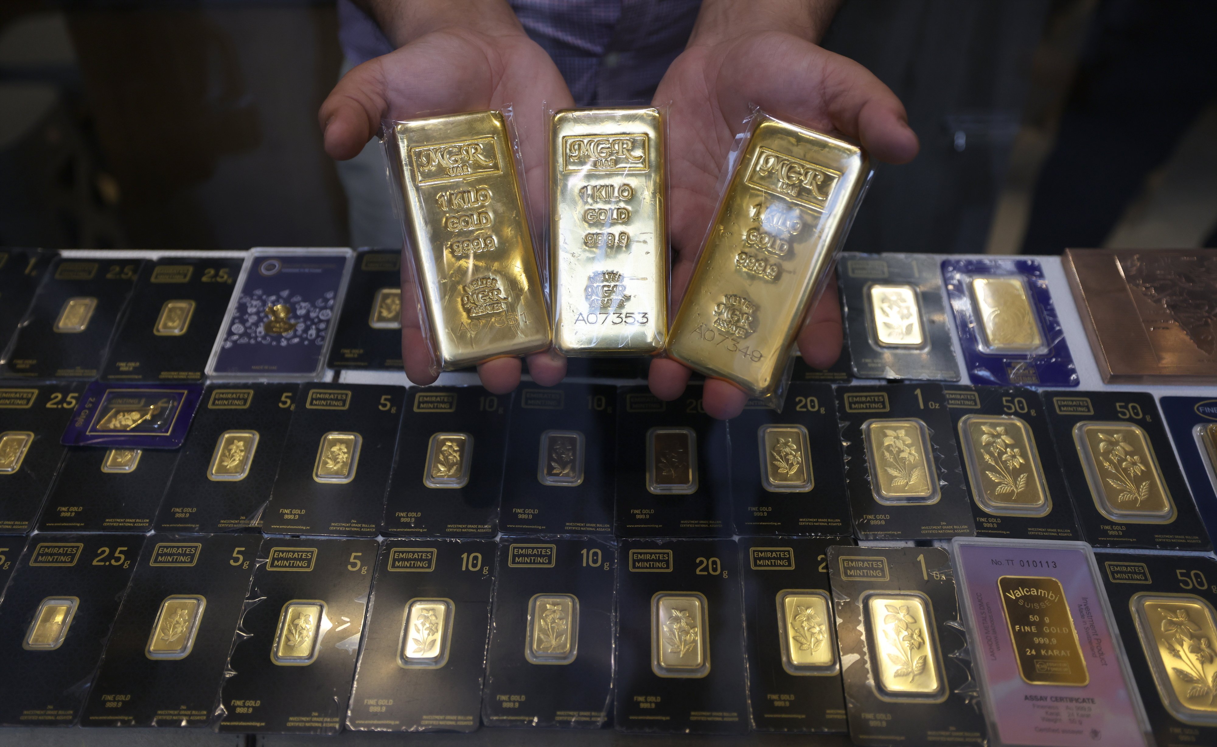 A salesman presents gold bars at a jewellery shop inside the Gold Market at the Old Souk in Dubai, United Arab Emirates on April 13. Photo: EPA