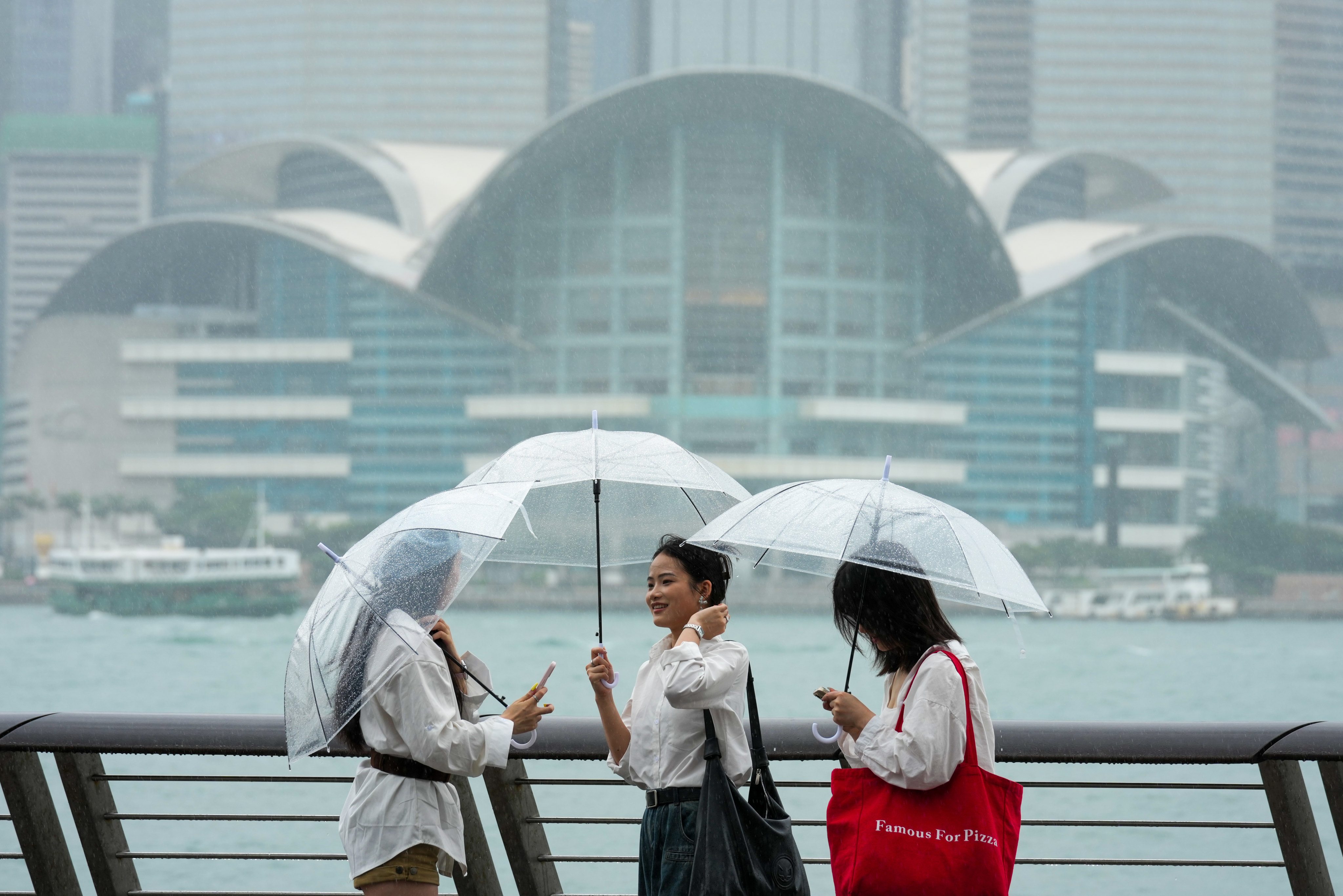 Tourists visit Tsim Sha Tsui waterfront in the rain. Photo: Jelly Tse