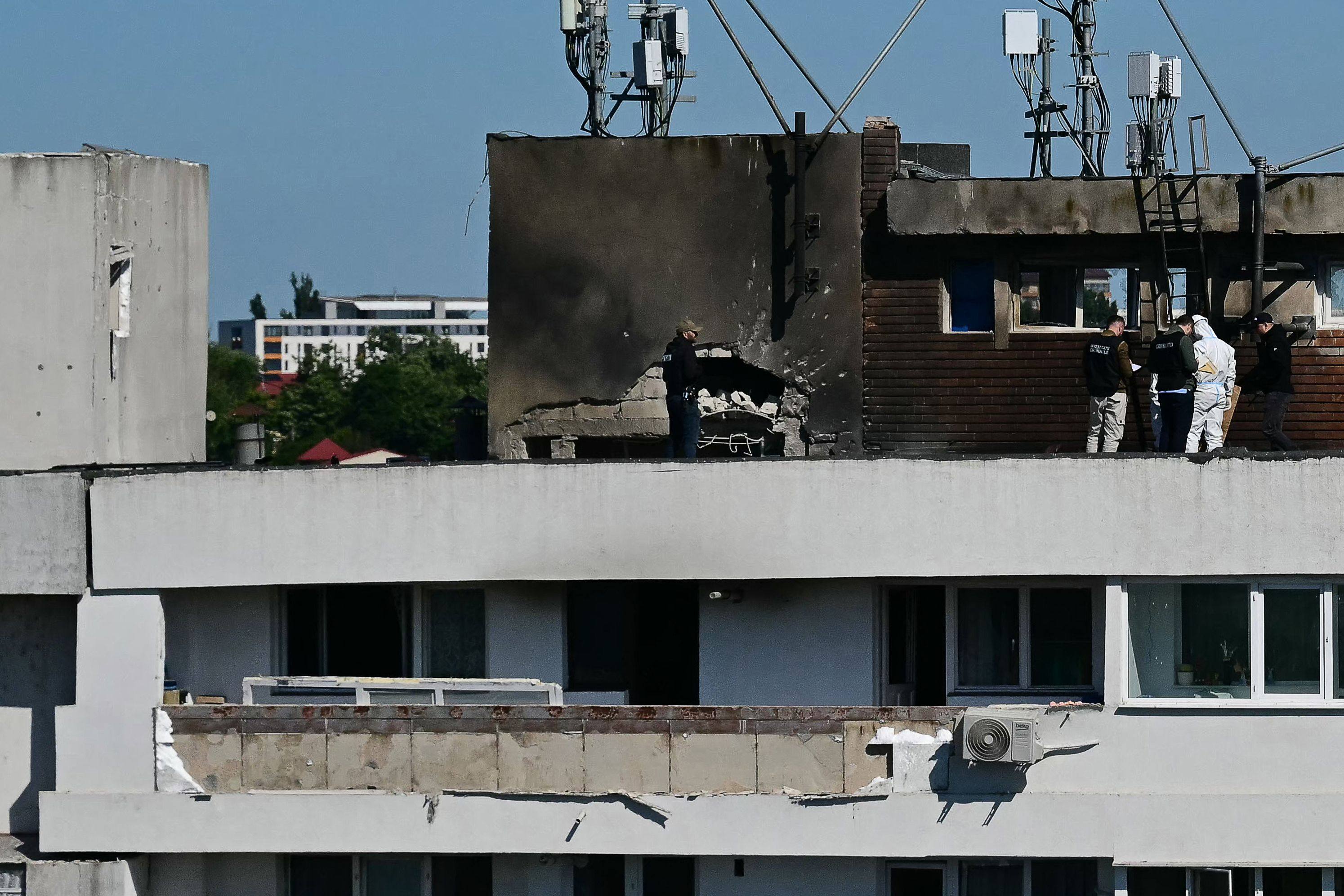 Investigators examine the rooftop impact zone of a building in Galați, Romania, after it was struck by an exploding Russian drone. Photo: AFP