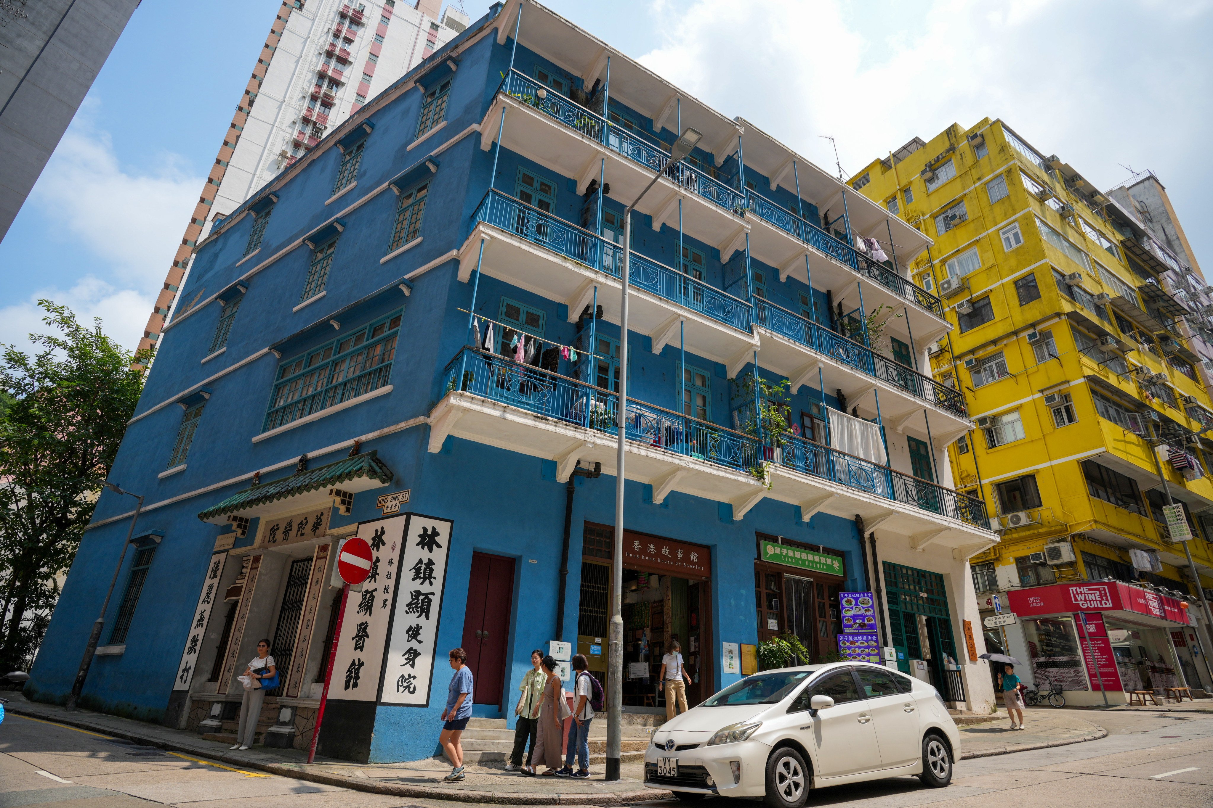 People walk past “Blue House”, a four-storey tenement block on Stone Nullah Lane, Wan Chai, on August 29, 2024. Photo: May Tse