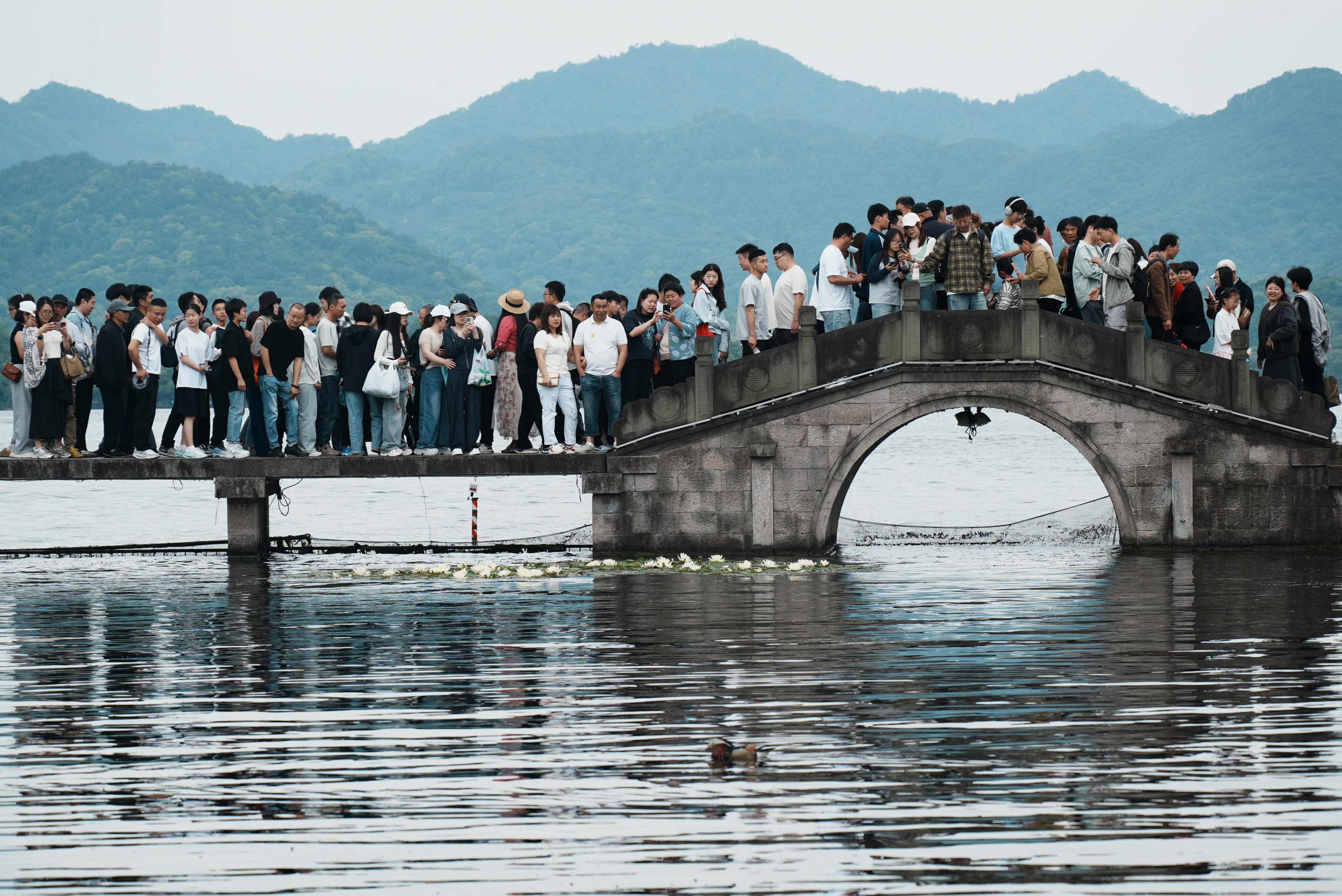 People crowd a walkway and bridge over West Lake in Hangzhou, Zhejiang province, on May 3 during the five-day Labour Day holiday. Photo: AFP