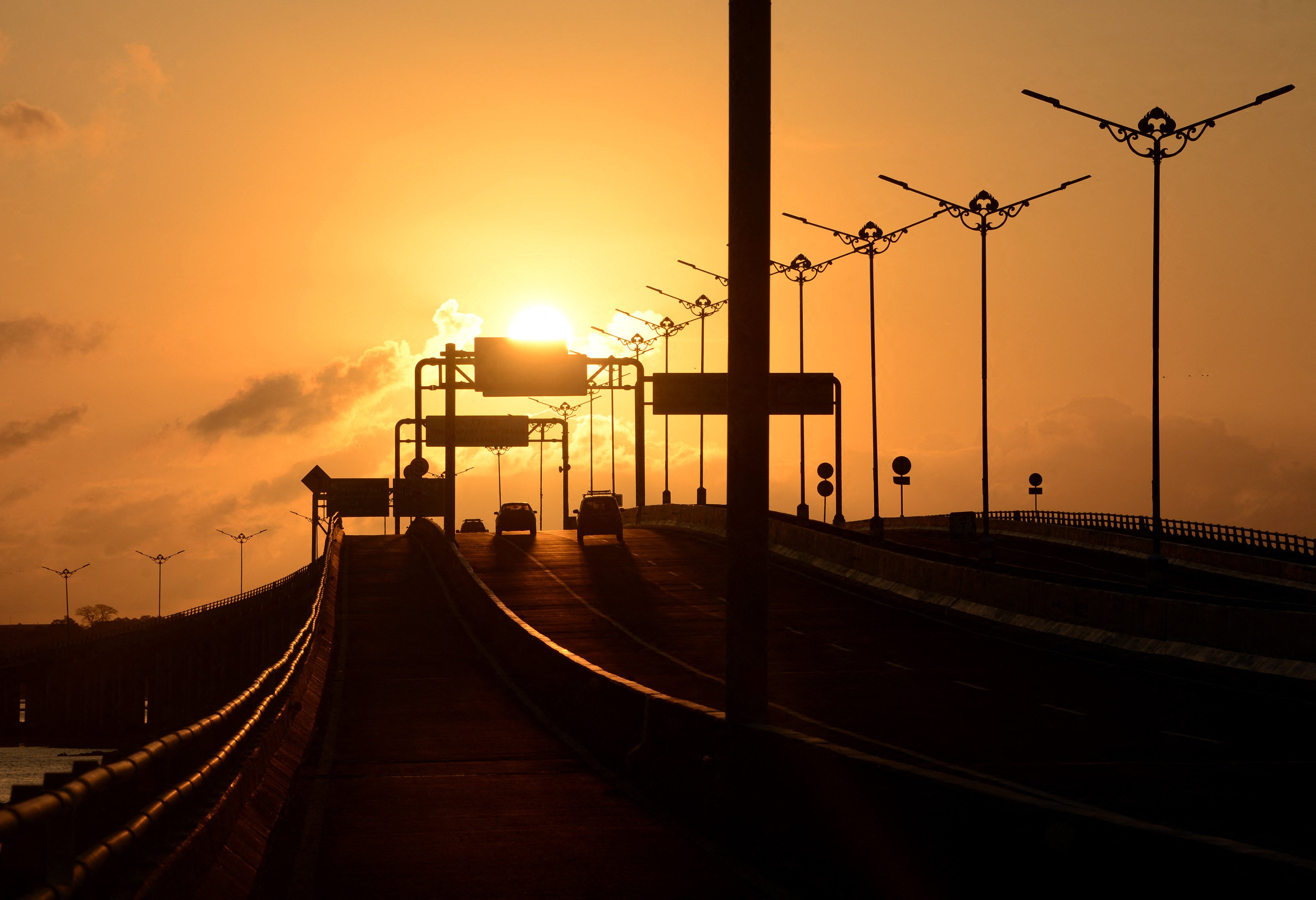 Cars drive along a road in Denpasar, on Indonesia’s resort island of Bali, at sunset. Photo: AFP