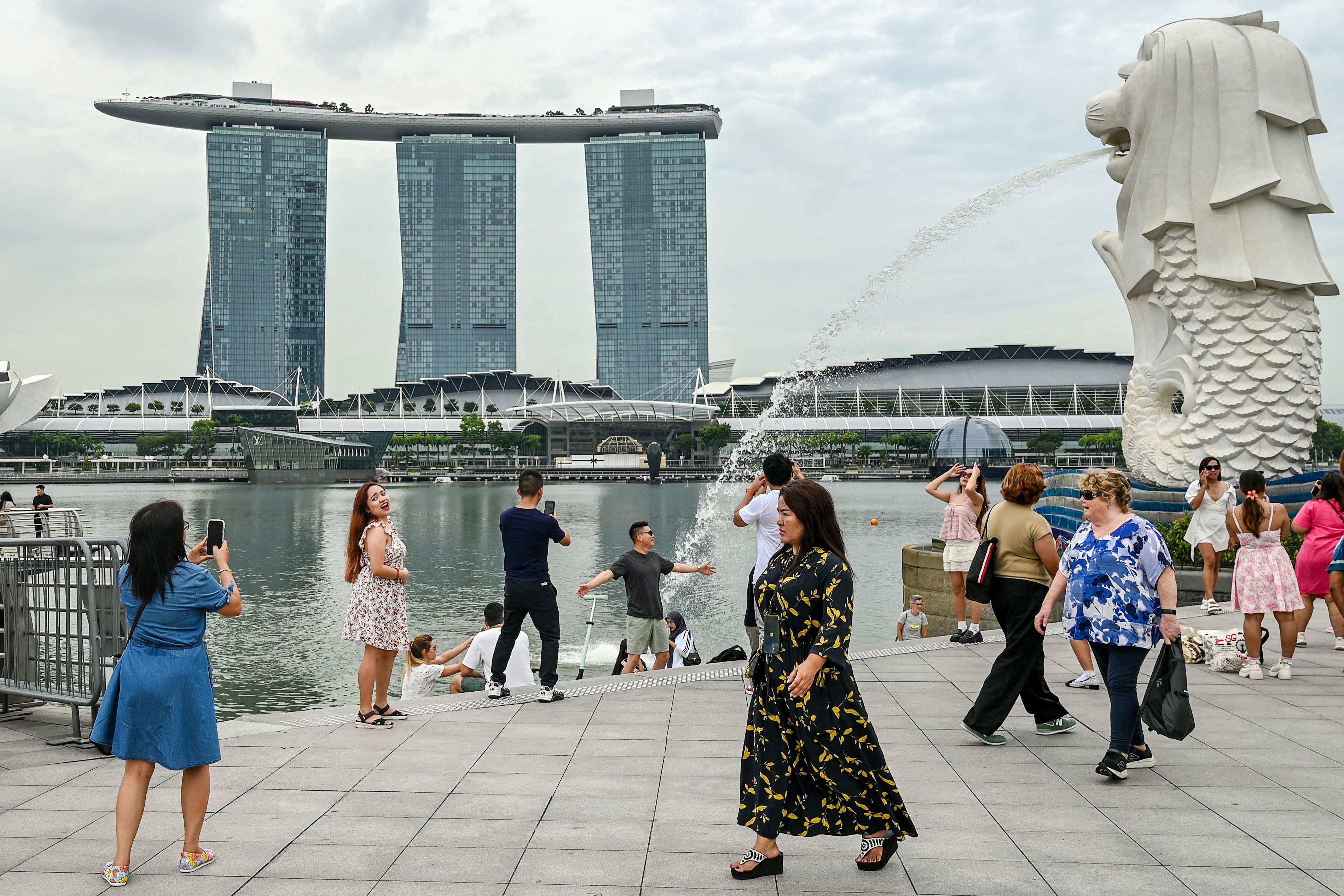 People at the Merlion statue in Singapore. The city state has emerged top among Southeast Asians who chose an Asean member as their preferred relocation destination, according to a survey. Photo: AFP