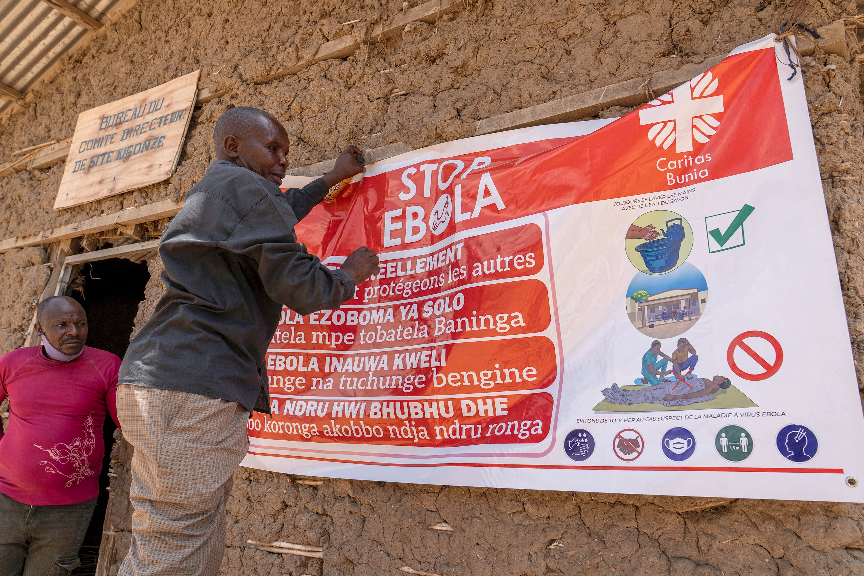 A man hangs an Ebola awareness banner in the Kigonze camp in Bunia, in the eastern Democratic Republic of the Congo on Thursday. Photo: TNS