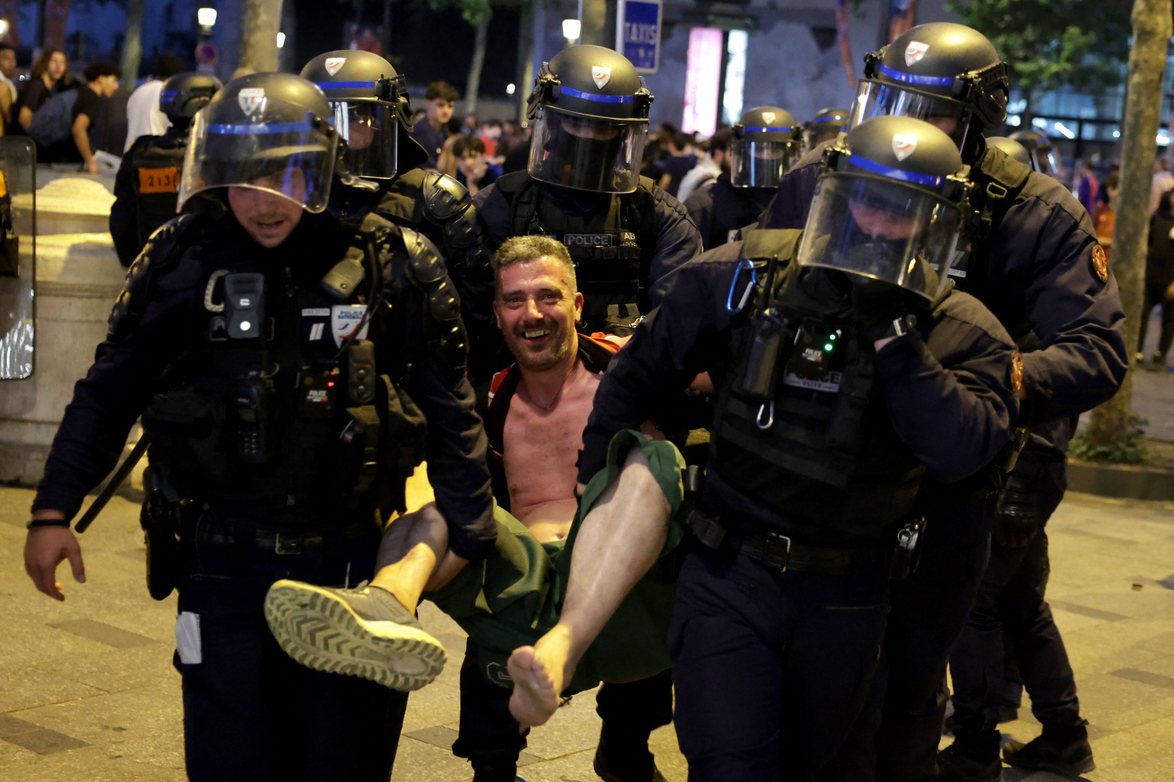 French police detain a PSG supporter during celebrations following their team’s win in the UEFA Champions League final between Paris Saint-Germain (PSG) and Arsenal FC, on the Champs-Élysées Avenue in Paris on Saturday. Photo: AFP