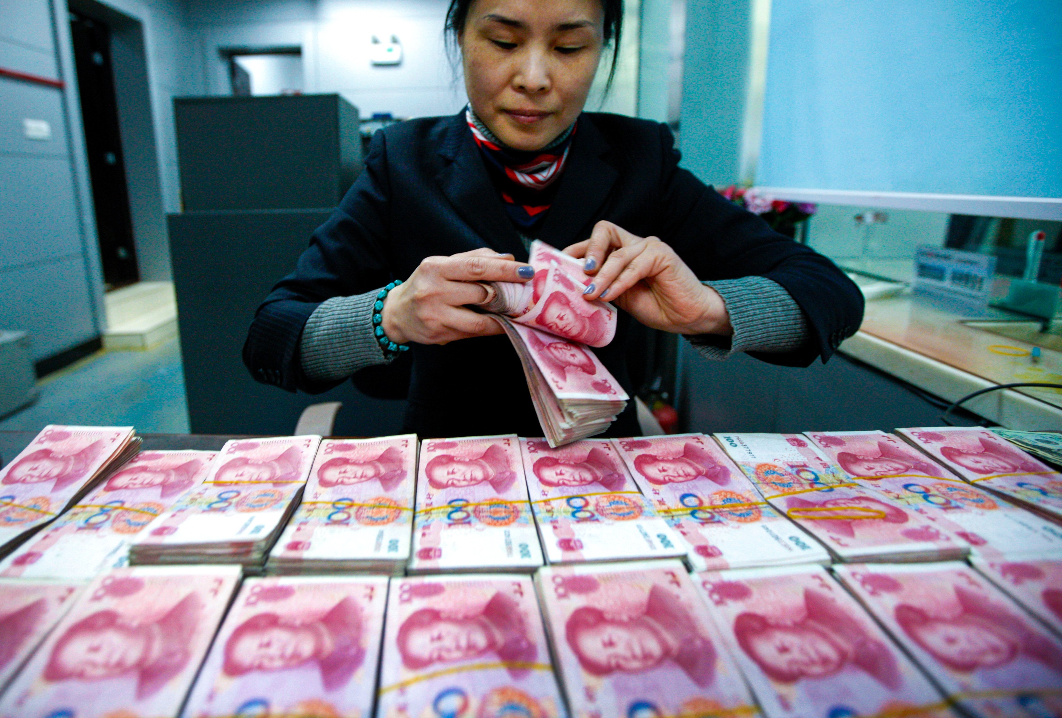 A clerk counts Chinese currency notes at a bank branch in Huaibei in central China’s Anhui province. Photo: AP