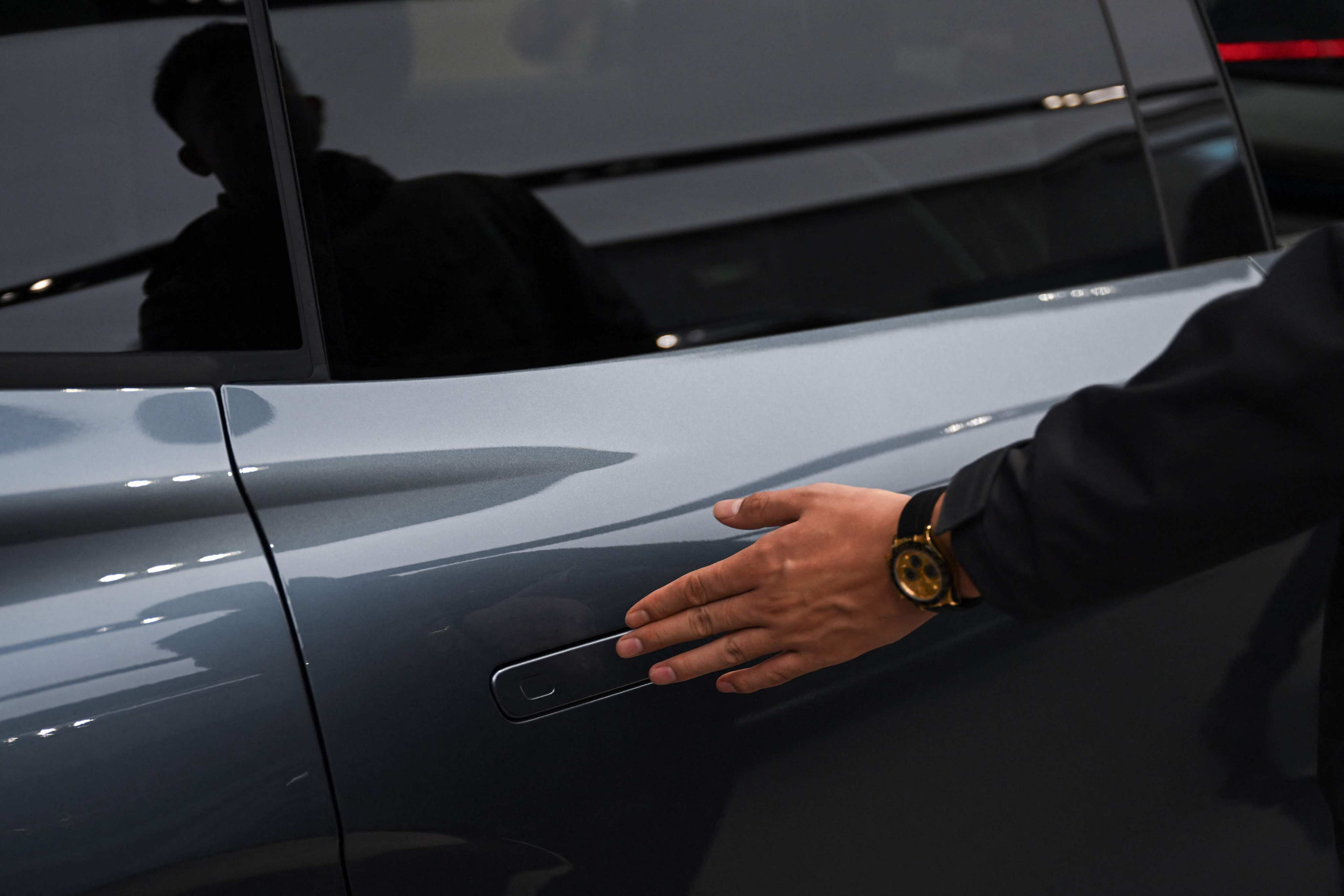 A man opens the door of a Zeekr X7 electric vehicle at a showroom in Beijing on February 3, 2026. Photo: AFP
