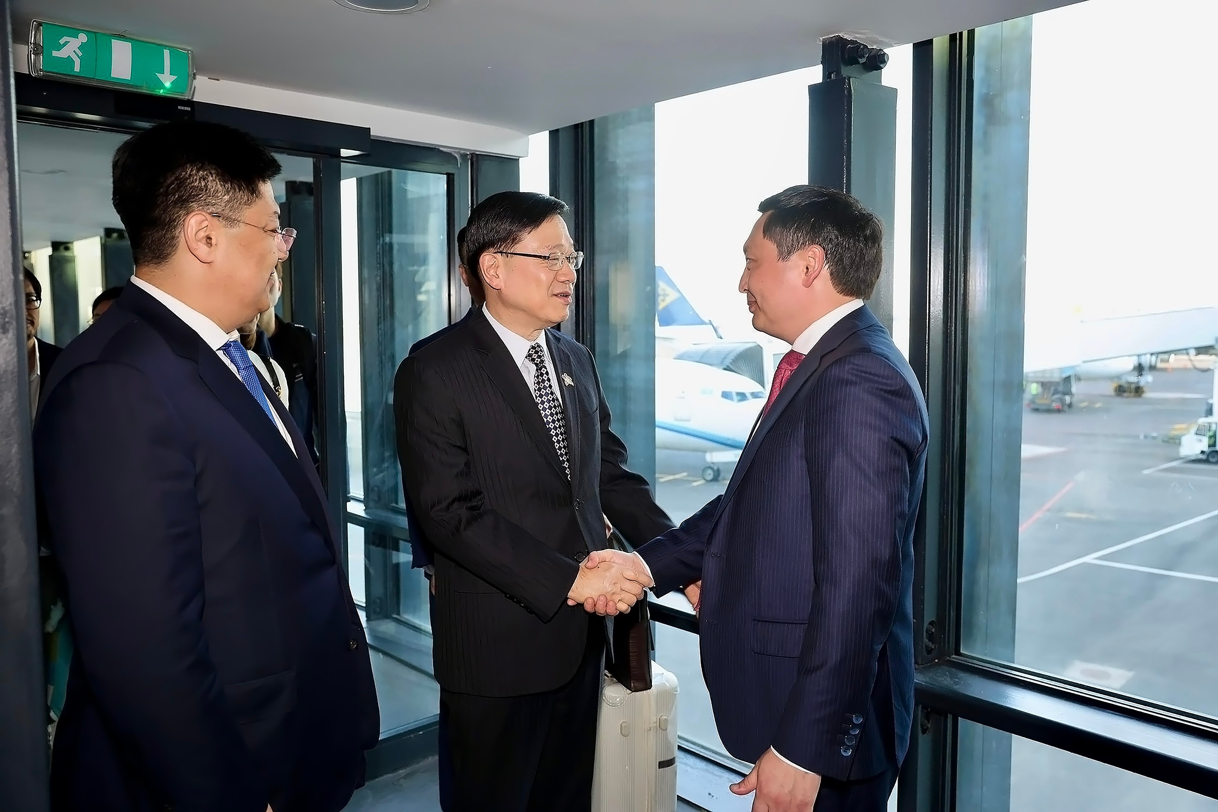 John Lee (centre) is greeted by national economy vice-minister Assan Darbayev. Photo: Facebook/ John Lee