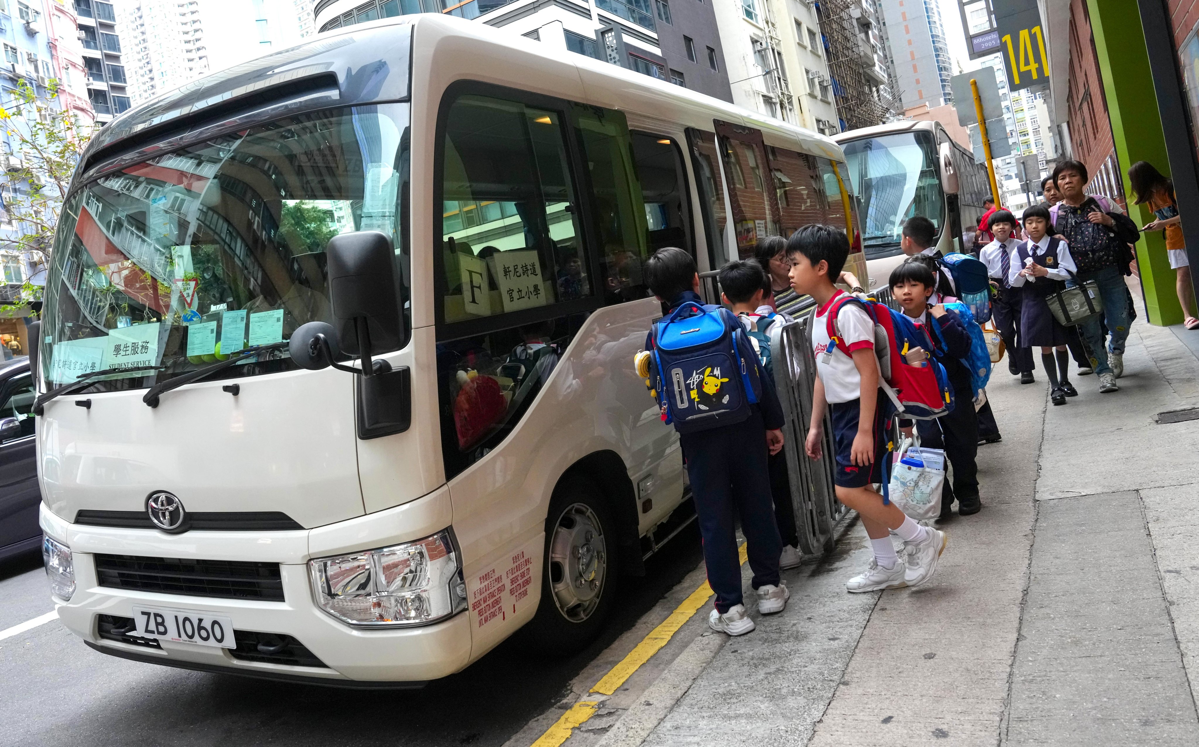 A school bus picks up pupils outside the Hennessy Road Government Primary School in Wan Chai on April 9. Photo: Jelly Tse
