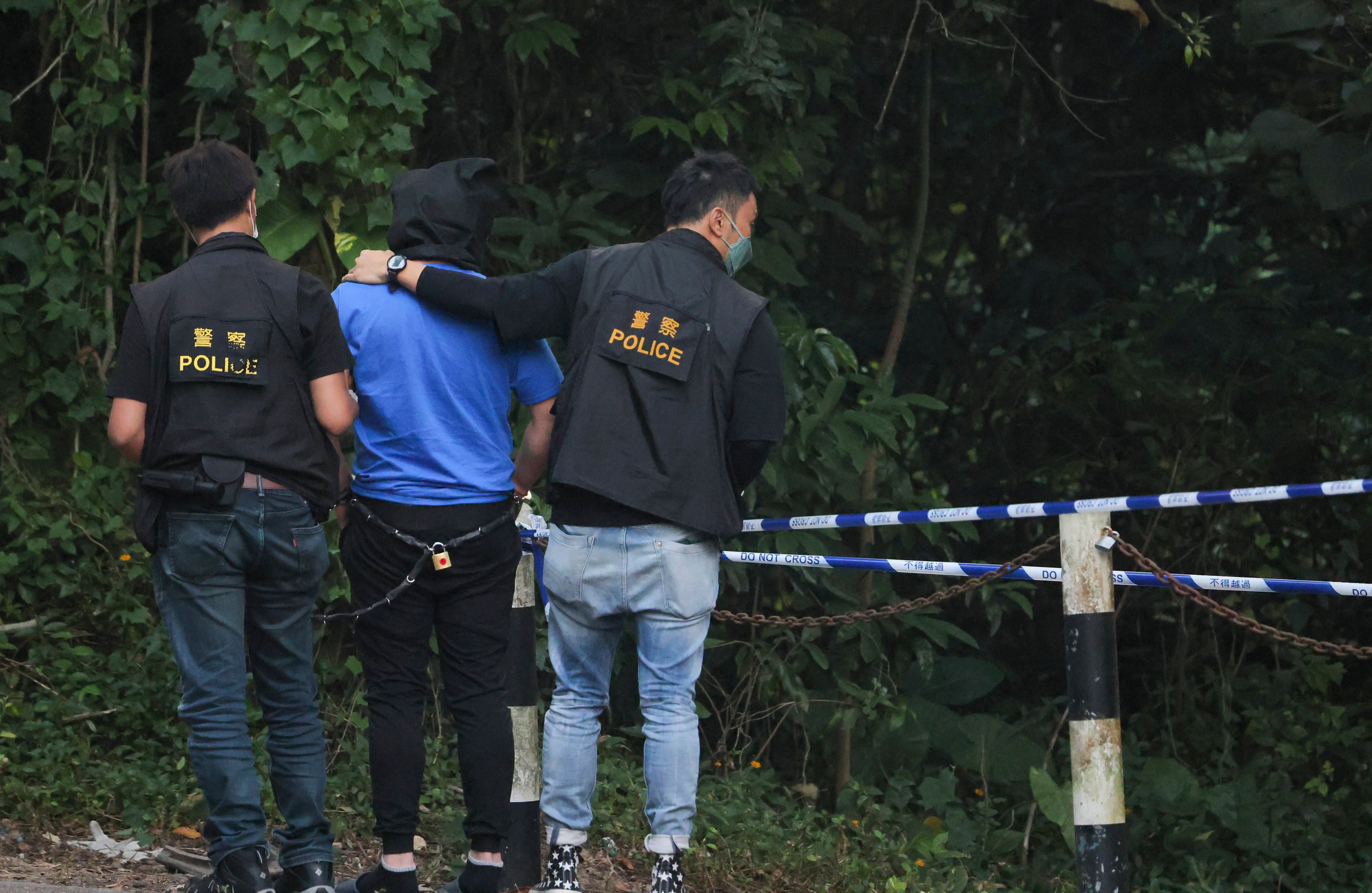 One of the suspects being escorted by police officers on a hillside near Ping Yeung Village in Ta Kwu Ling after the 2022 murder. Photo: Jelly Tse