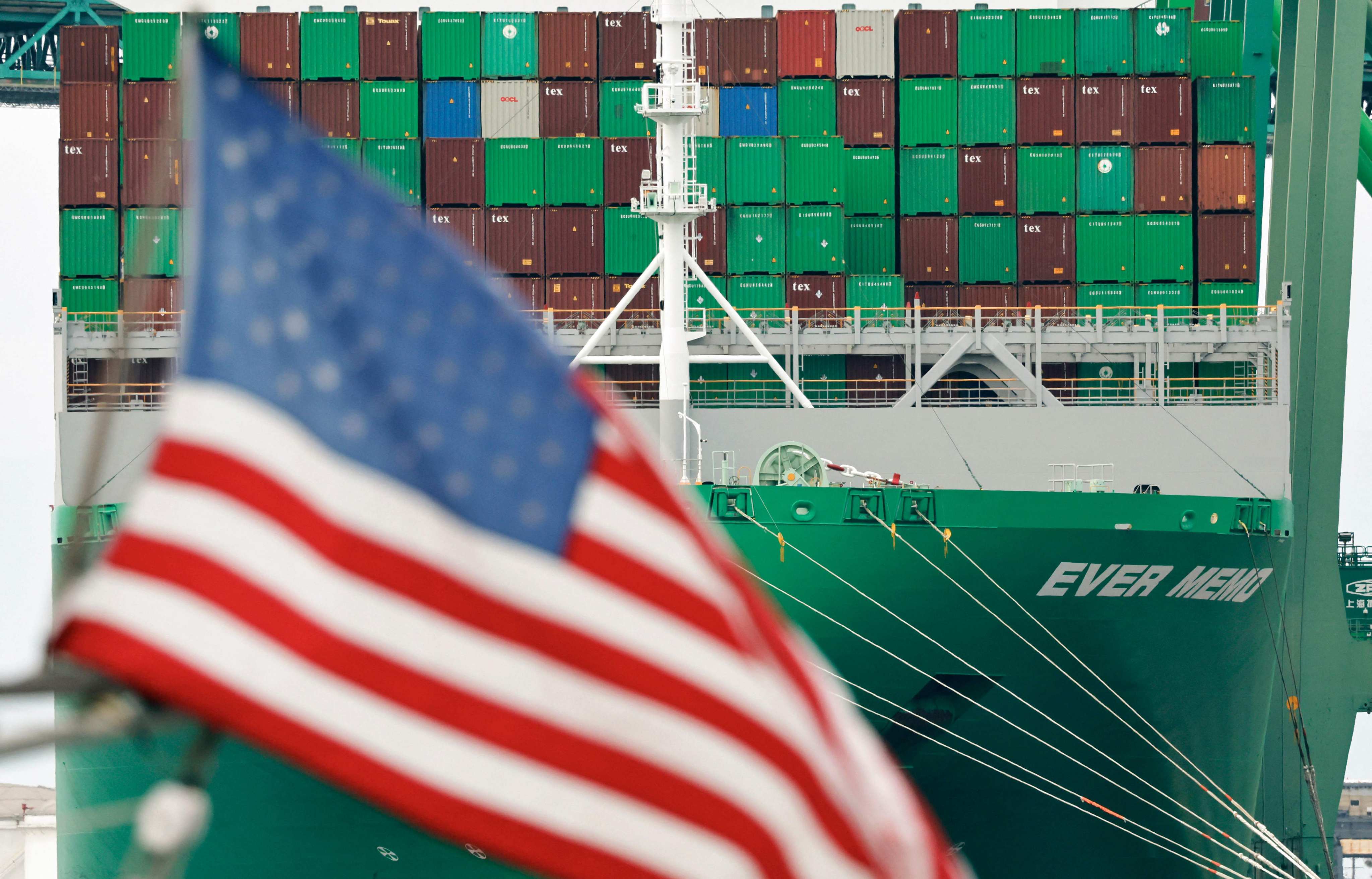 An American flag flies near a container ship at the Port of Los Angeles in May. Photo: AP