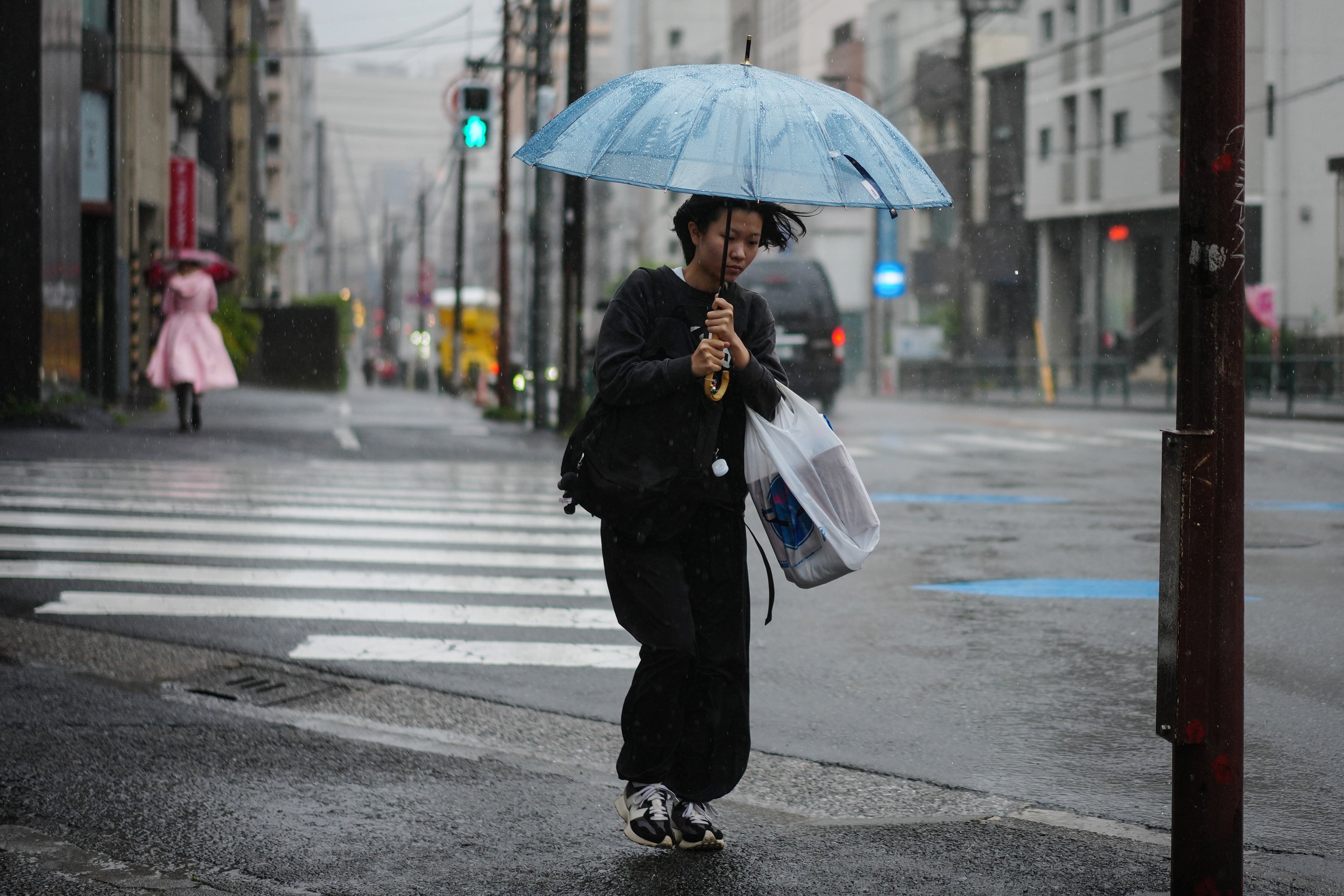 A pedestrian braves the rains brought by Typhoon Jangmi in Tokyo on Wednesday. Photo: Xinhua
