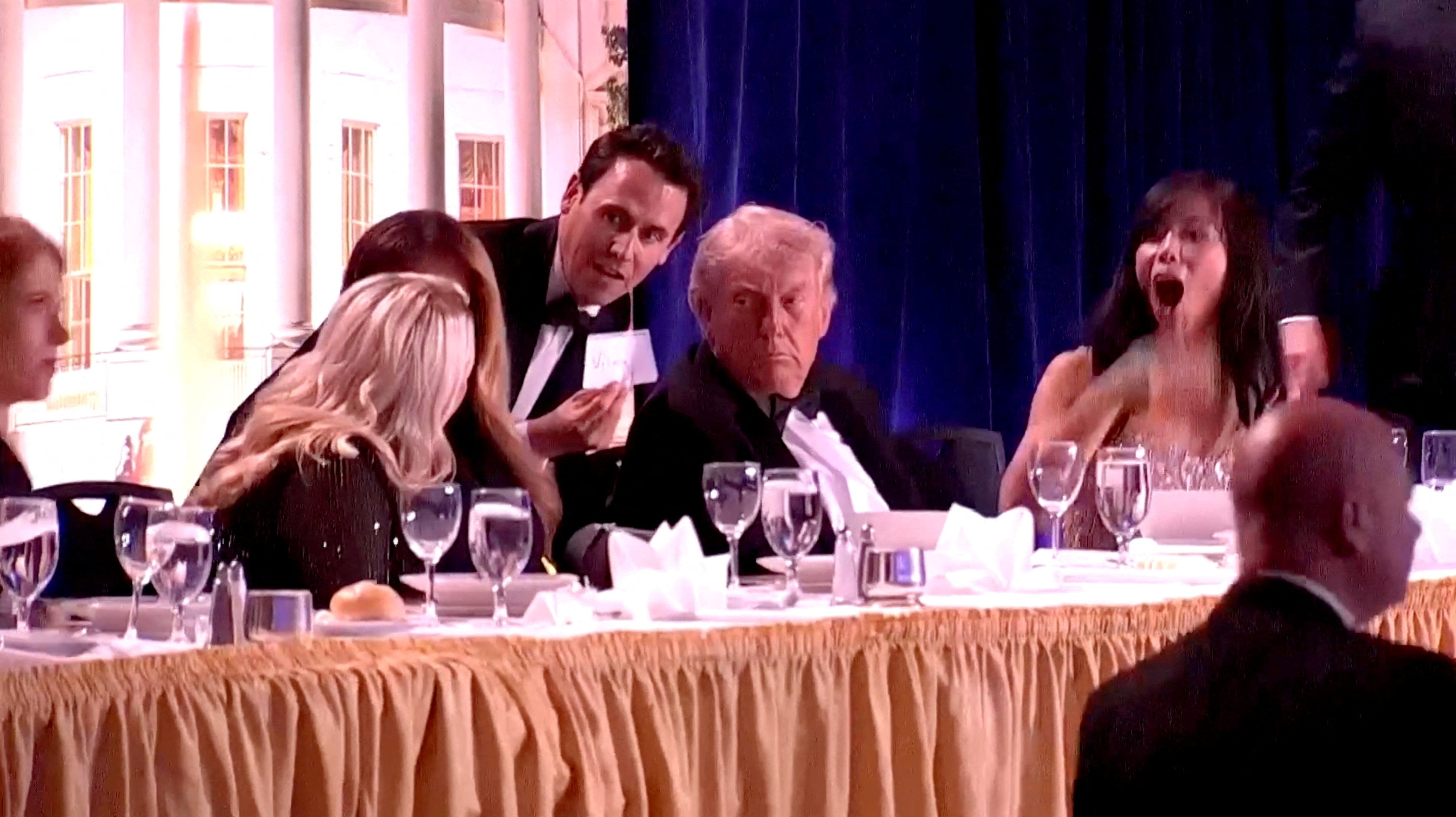 A staff member shows a note to US President Donald Trump, first lady Melania Trump and White House Press Secretary Karoline Leavitt, as CBS News senior White House correspondent Weijia Jiang reacts to a loud noise during the annual White House Correspondents’ Association dinner in Washington in April. Photo: Reuters