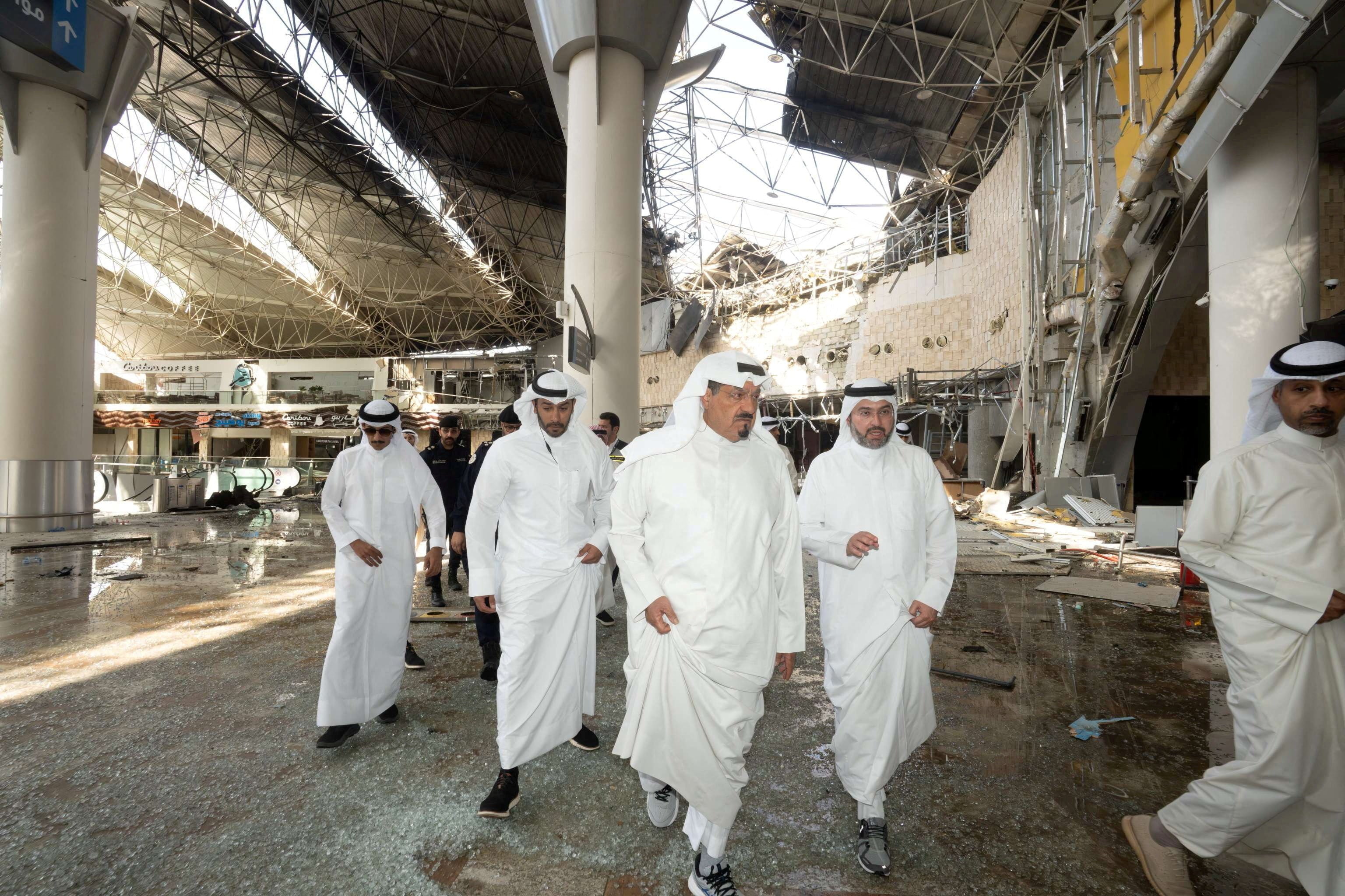 Kuwaiti officials inspect damage inside a terminal at Kuwait International Airport following a drone and missile attack. Photo: Kuwait News Agency via Reuters