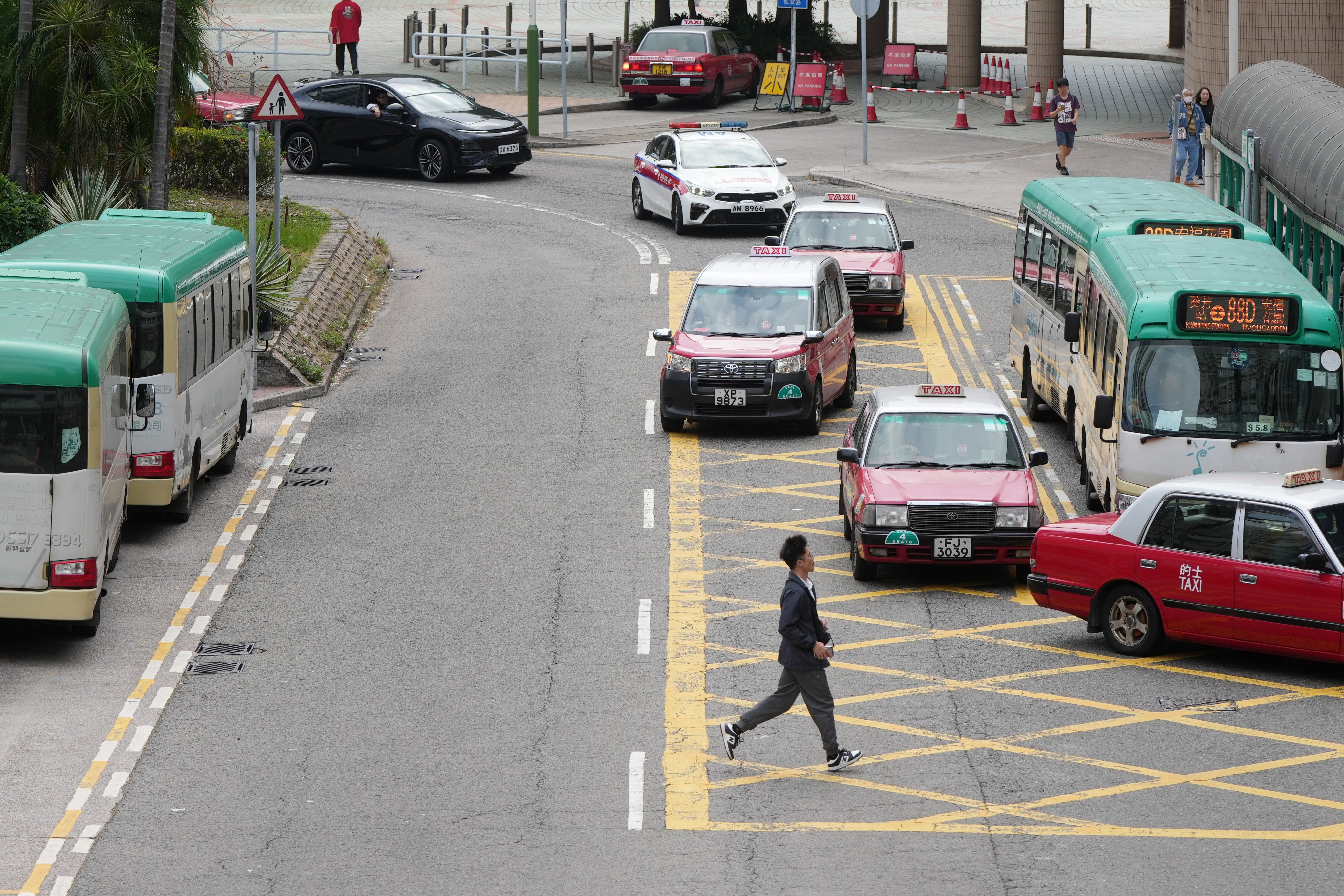 A pedestrian crosses a road in front of traffic in Kwai Fong. Photo: Sam Tsang