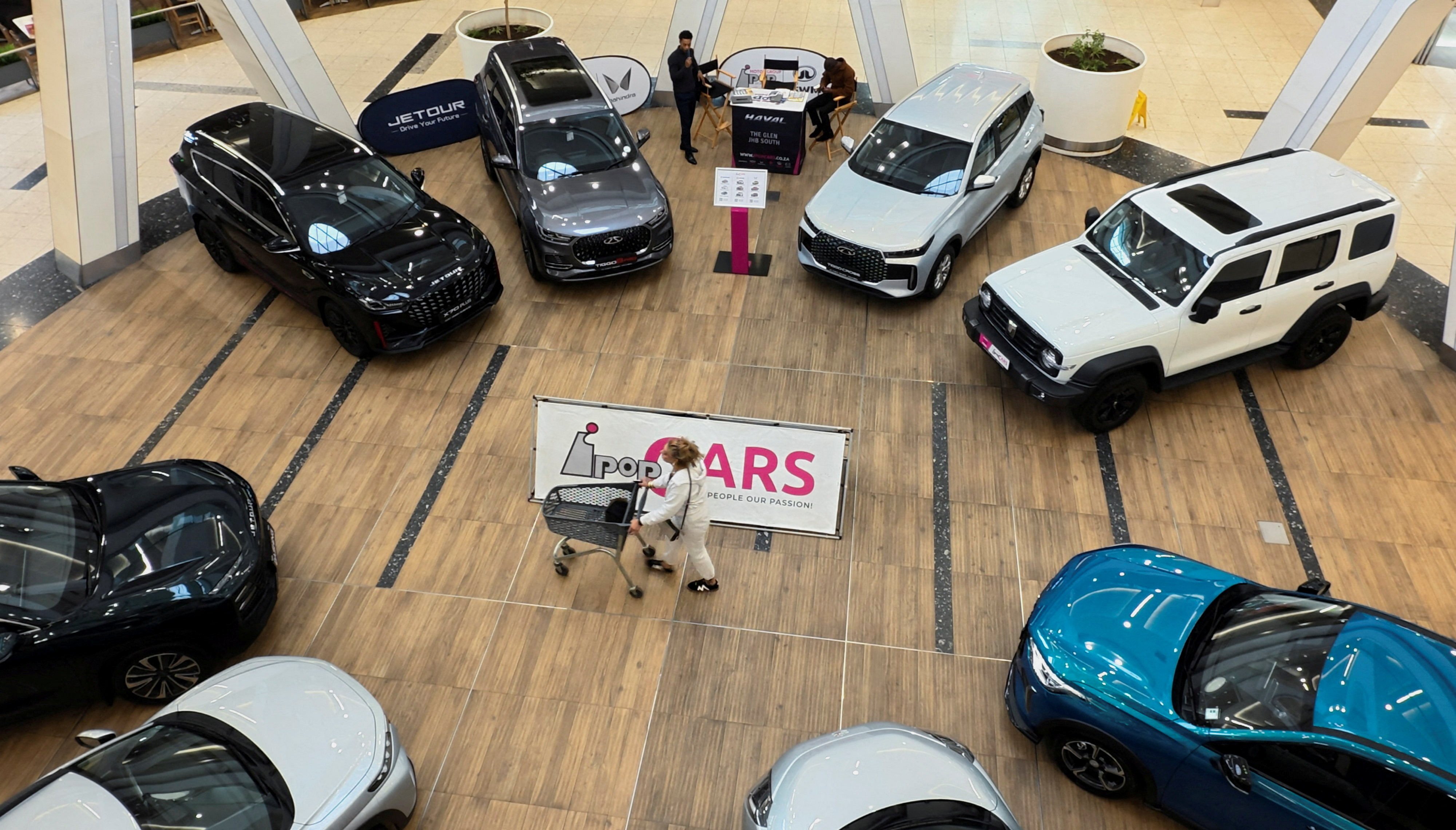 A shopper passes a display of Chinese-made cars, including models from Chery and Omoda, in a shopping centre in Johannesburg, South Africa, on April 23. Photo: Reuters