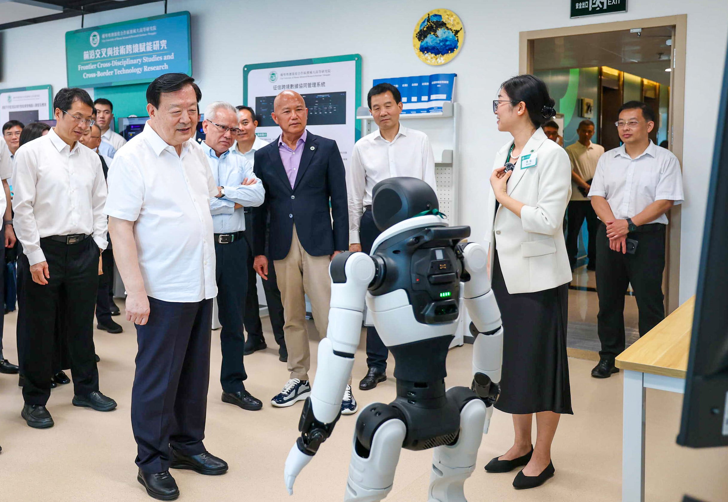 HKMAO's Xia Baolong (second left) watches as a robot demonstrates its skills.  Photo: Handout