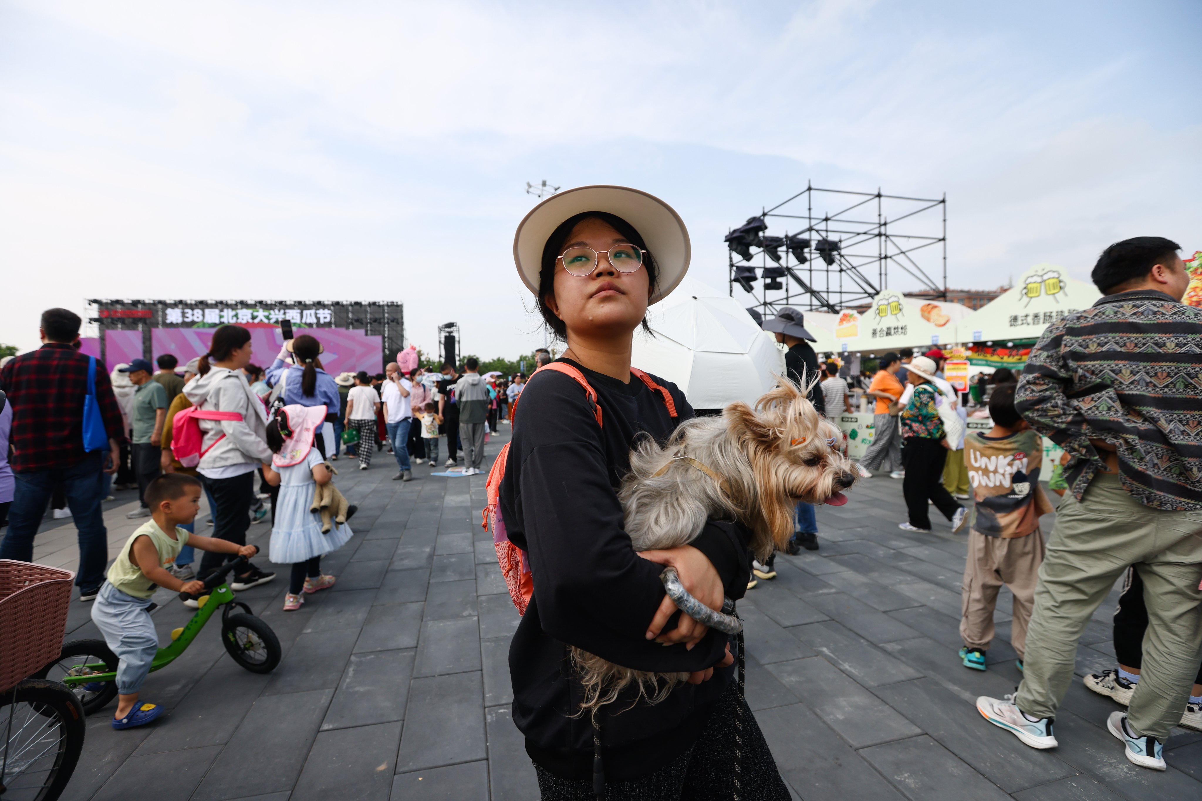 A woman and her pet dog visit the Daxing Watermelon Festival in Beijing last month. Photo: EPA