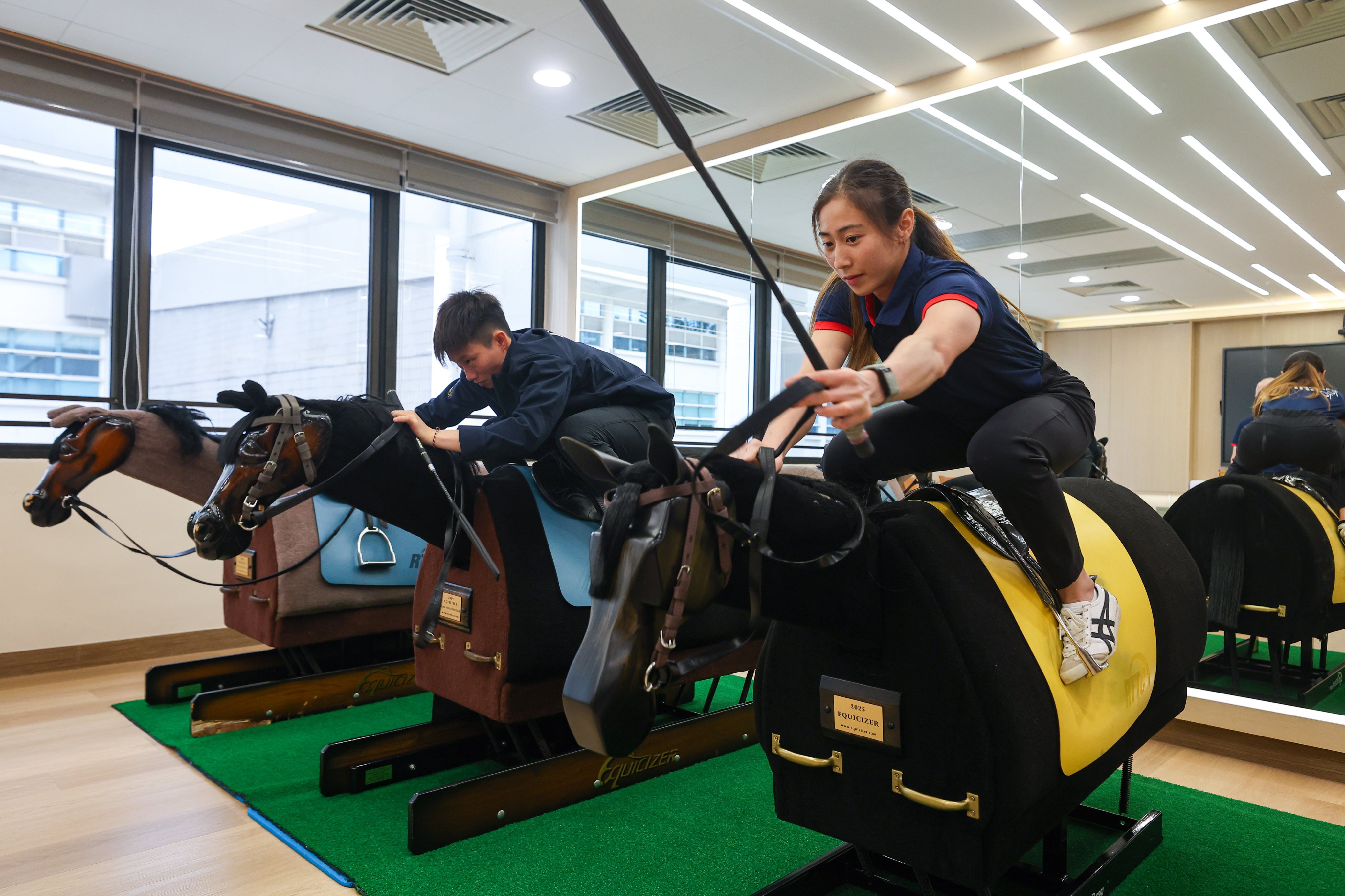 Apprentice jockeys Nichola Yuen (left) and Britney Wong practising on mechanical wooden horses at the Hong Kong Jockey Club's Apprentice Jockeys’ School in Sha Tin. Photo: Edmond So