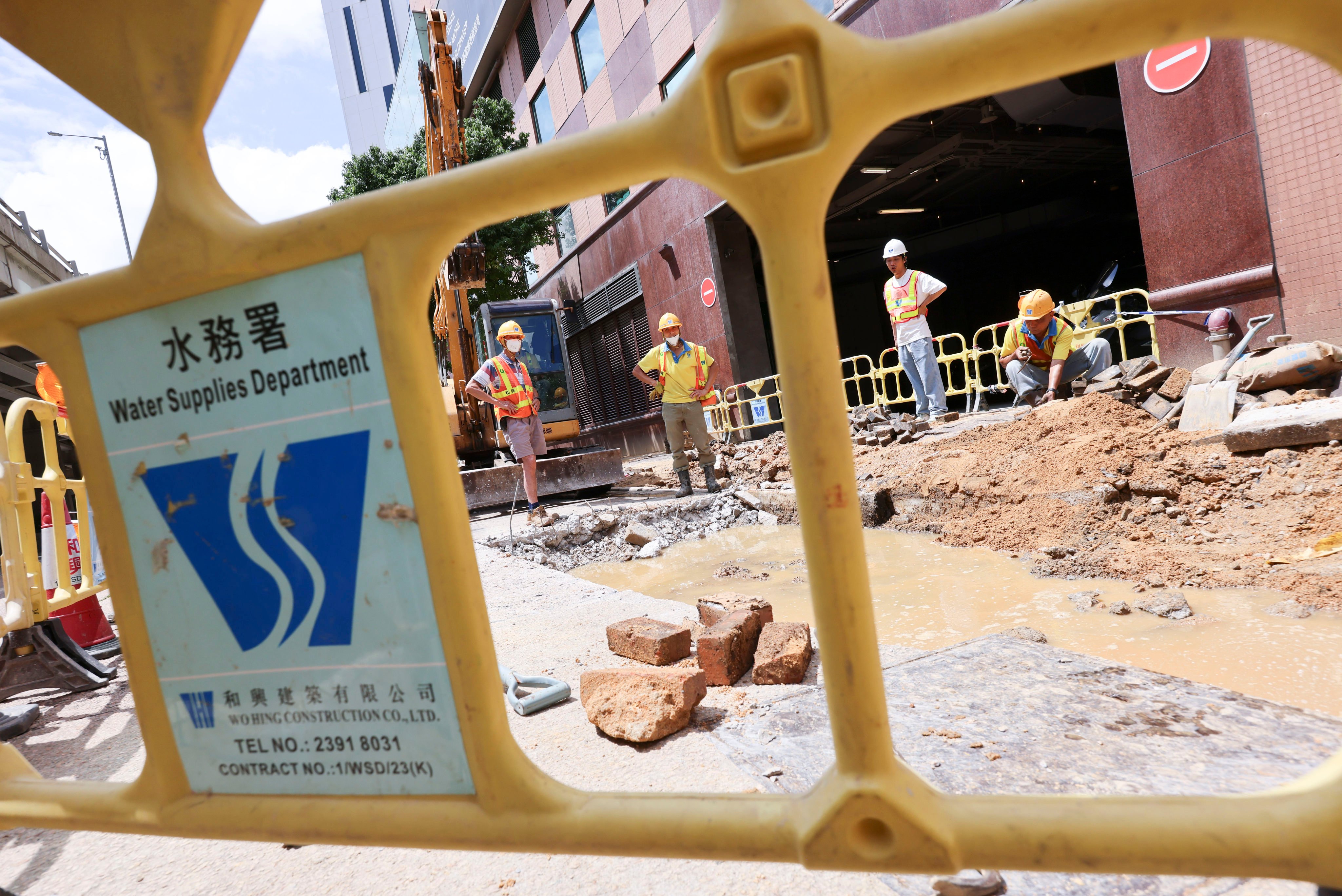 Repair workers contemplate a puddle along Gascoigne Road in Kowloon on June 12, 2025, following a saltwater leak. Photo: Jelly Tse