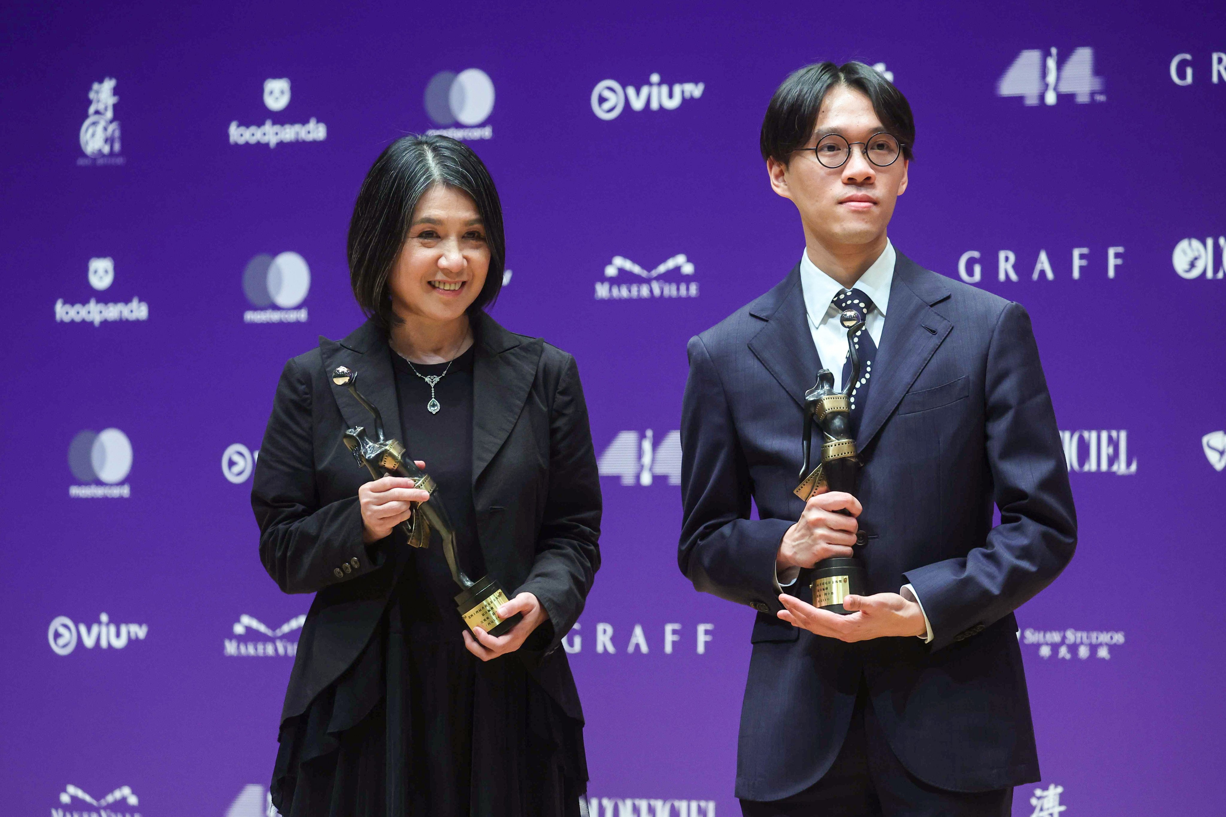 Kong Ho-yan (right) and Amy Chin hold up their Best Screenplay trophies at the 44th Hong Kong Film Awards. Photo: Edmond So