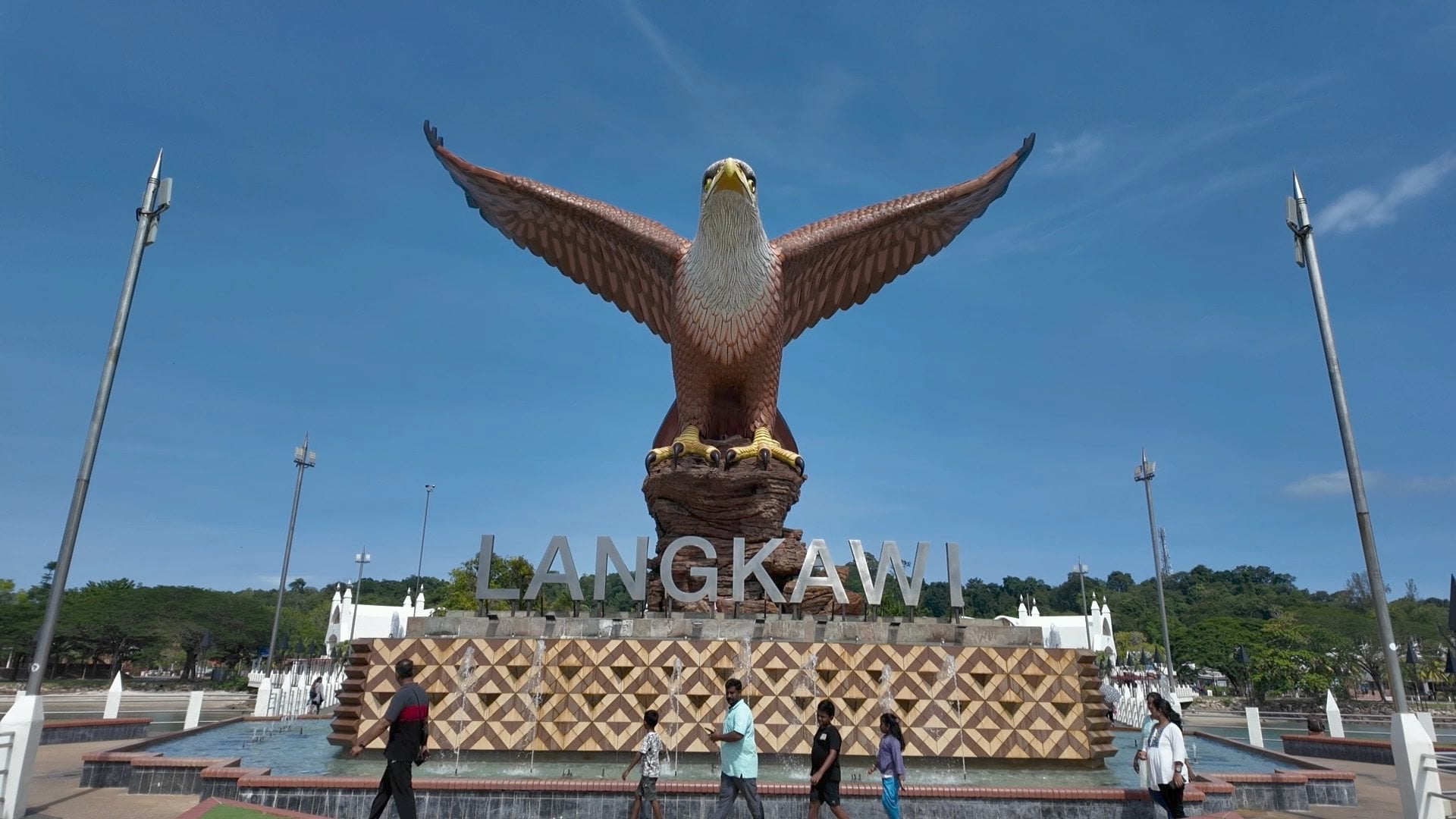 Tourists walk past the eagle statue landmark in Langkawi, Malaysia. Photo: Ushar Daniele