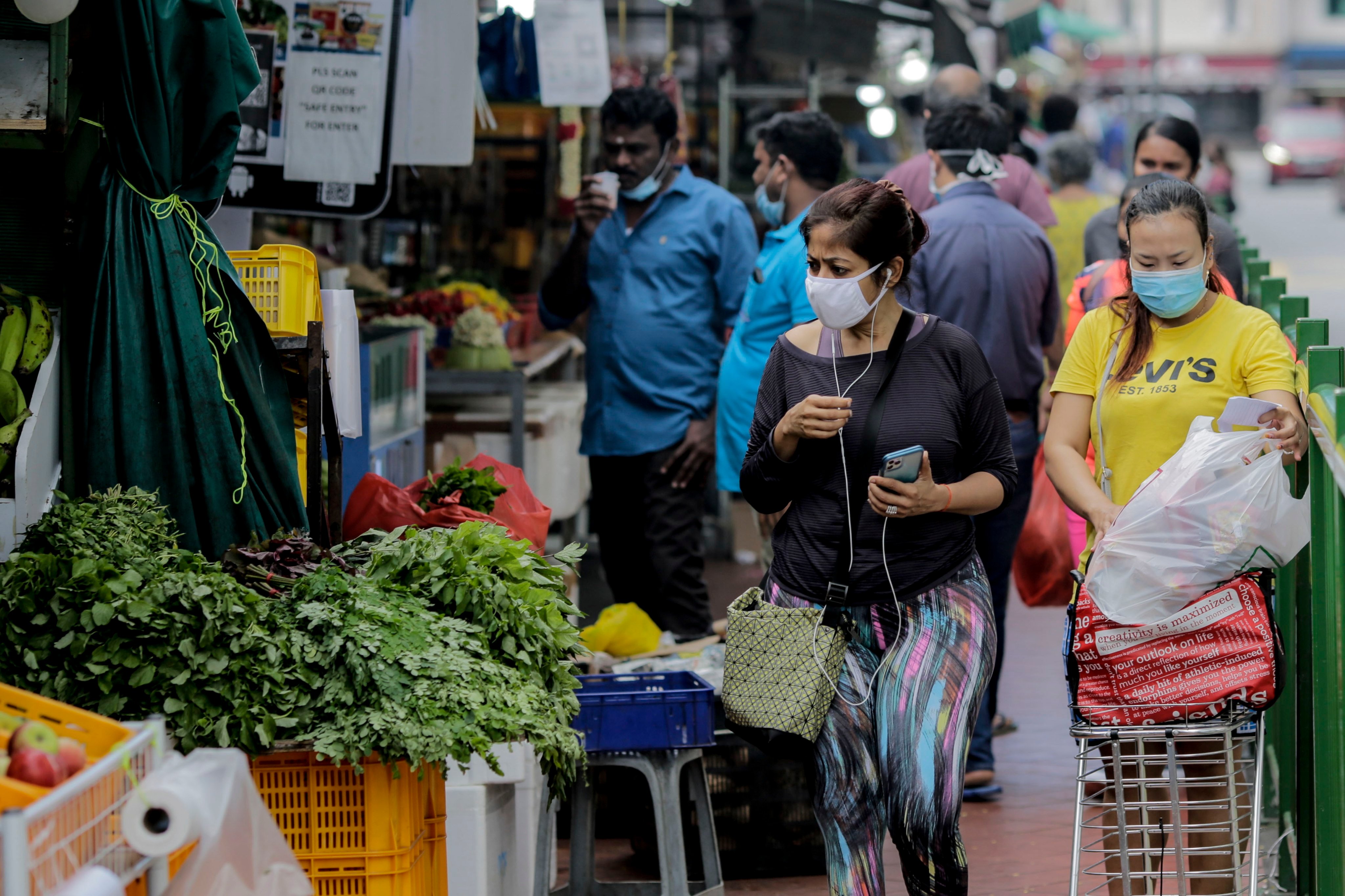 A woman inspects a vegetable stall in the Little India district of Singapore in July 2020. Photo: EPA-EFE