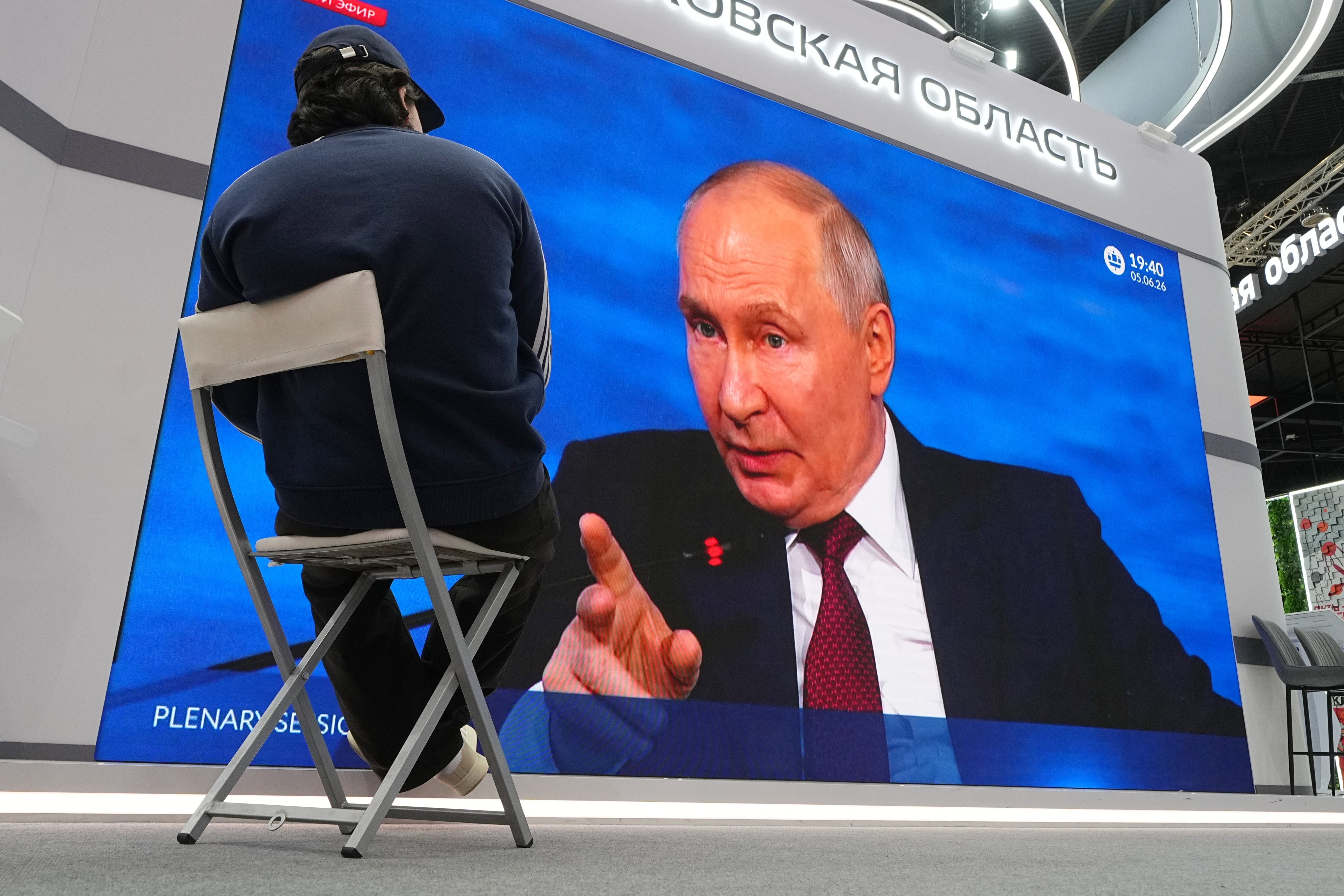 A participant watches a broadcast of Russian President Vladimir Putin’s speech on a screen during the St Petersburg International Economic Forum on Friday. Photo: AP