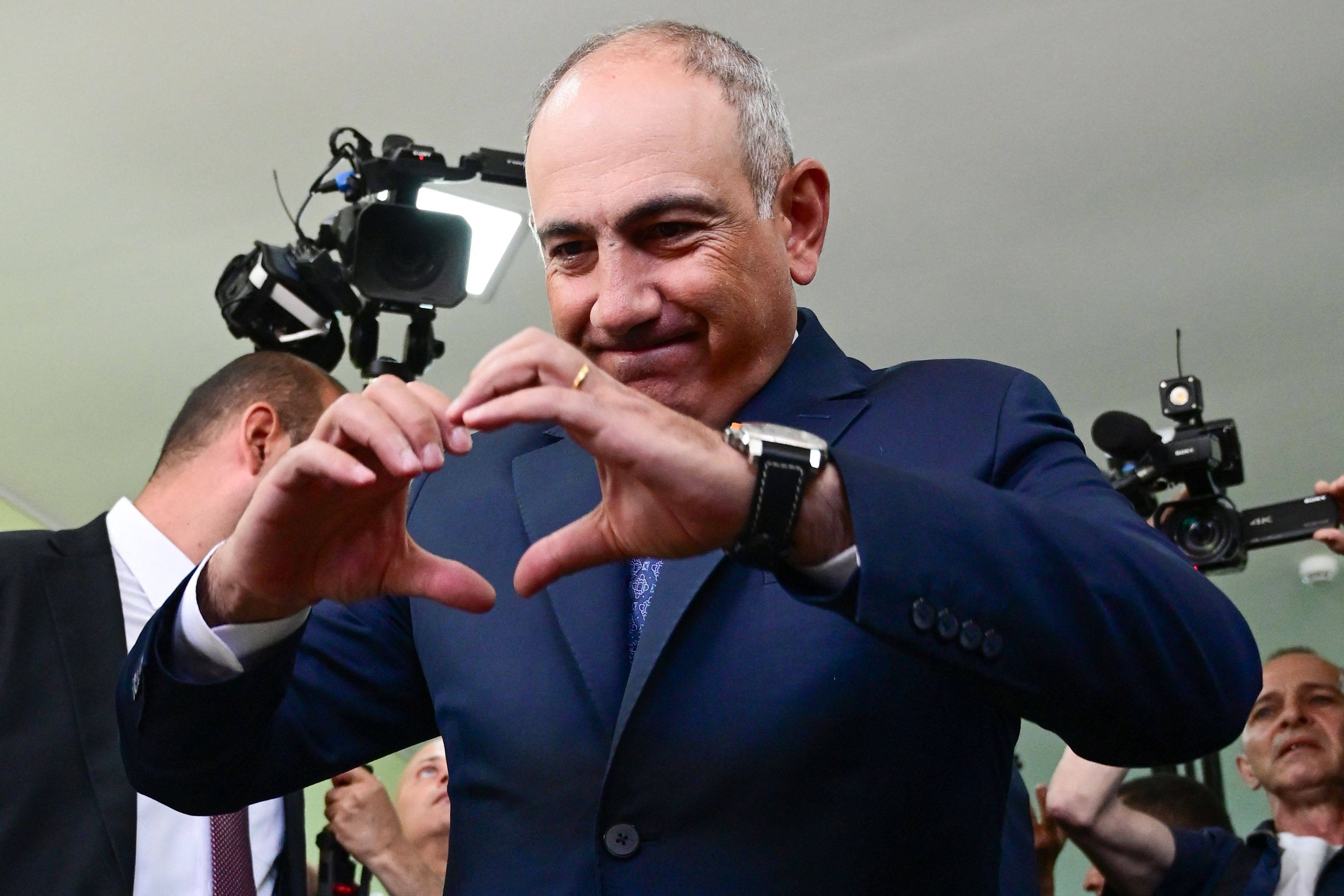 Armenian Prime Minister Nikol Pashinyan makes a heart with his hands after casting his ballot in the parliamentary election at a polling station in Yerevan on Sunday. Photo: AFP