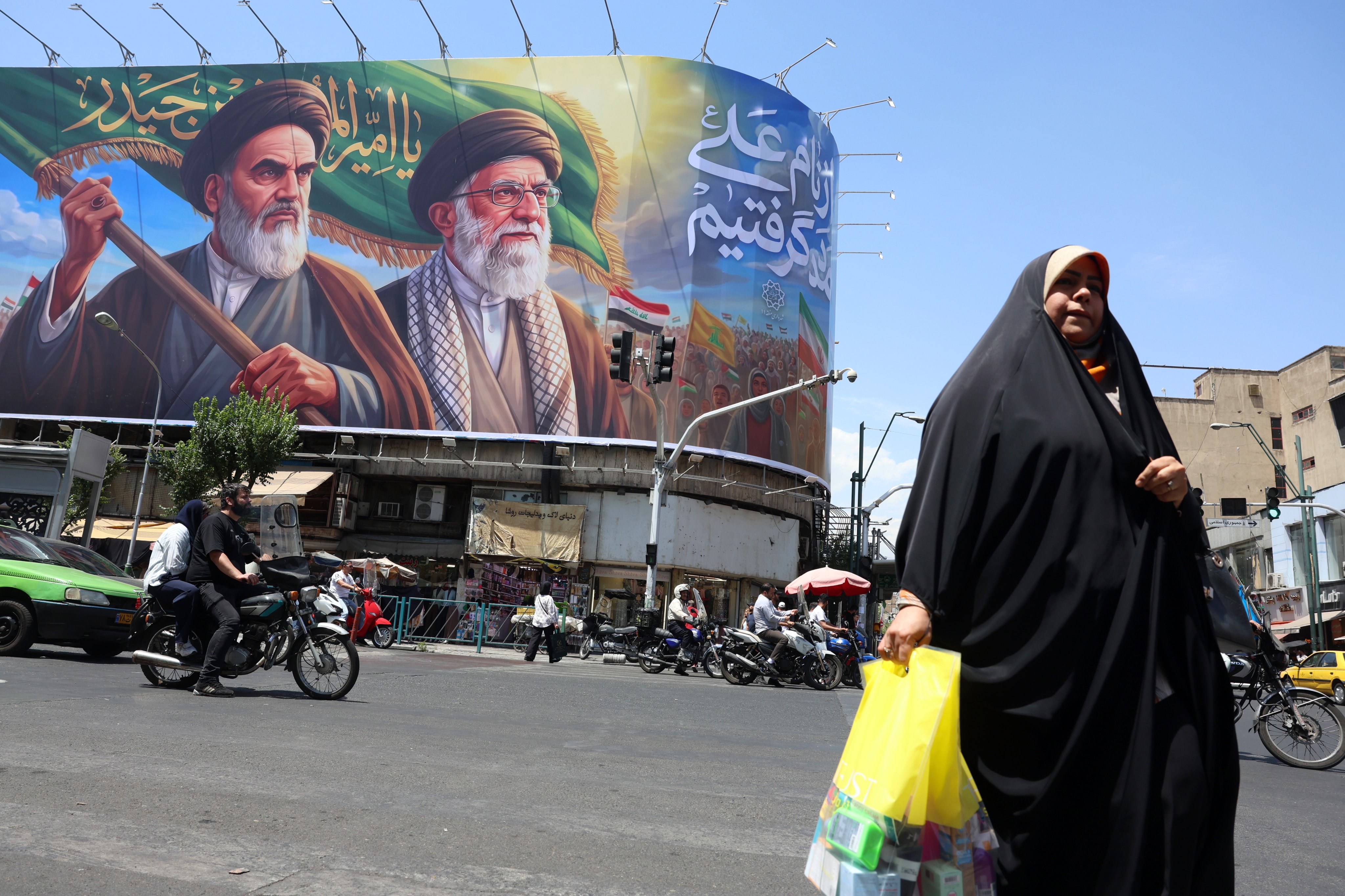 Iranians walk past a huge billboard featuring previous supreme leaders Ayatollah Ruhollah Khomeini and Ayatollah Ali Khamenei, on a street in Tehran, Iran, on Sunday. Photo: EPA-EFE