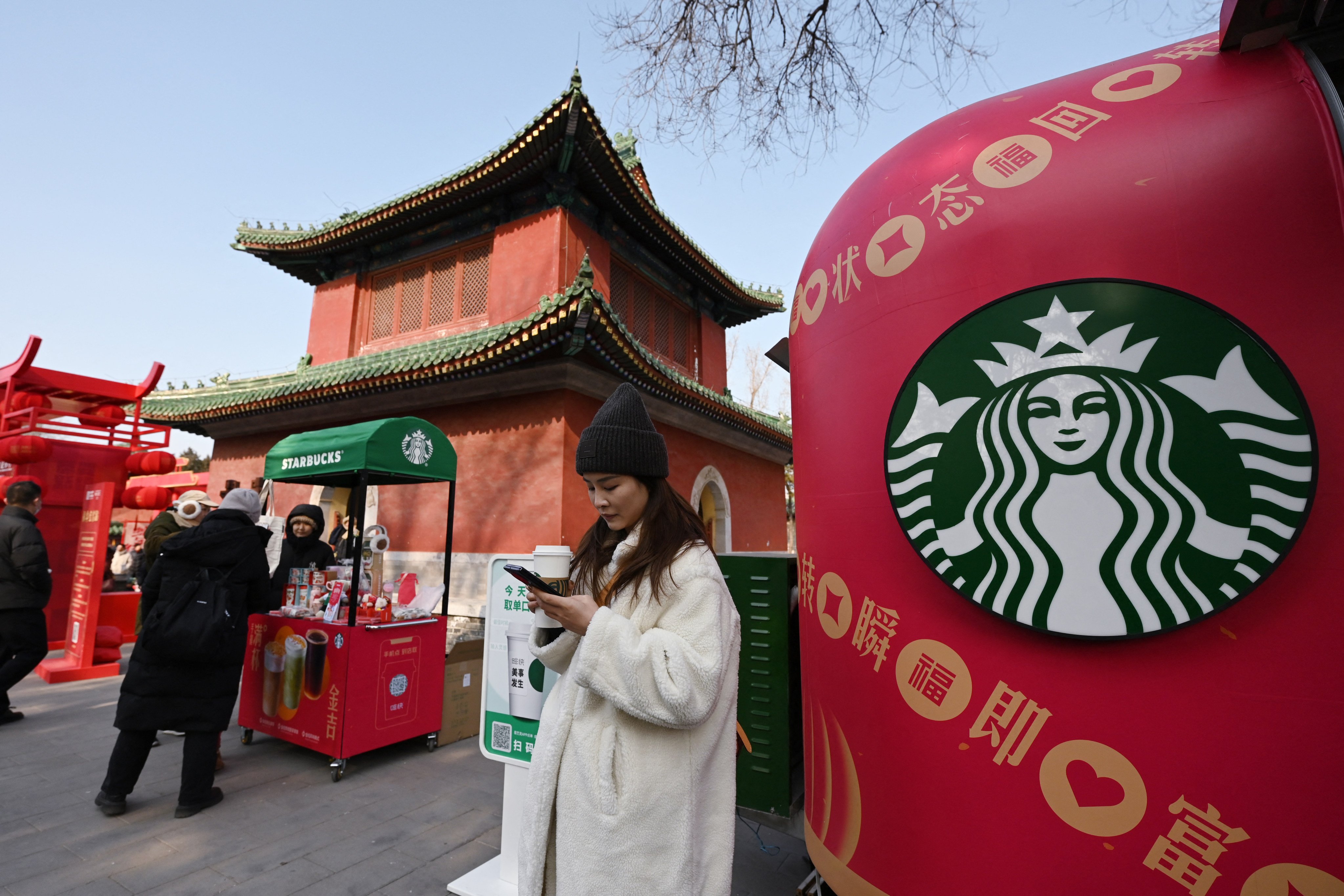 People buy coffee at a mobile Starbucks set up next to a historic building in Beijing on January 30, 2025. Photo: AFP