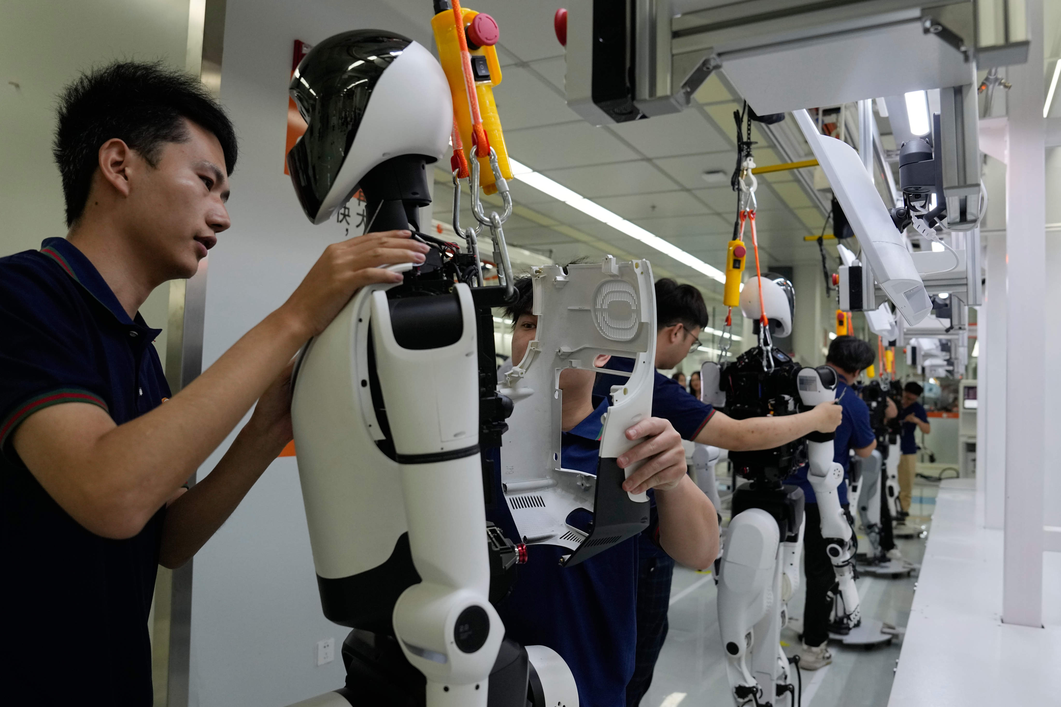 Workers assemble robots at the LY iTech Beijing Super Factory for Embodied Artificial Intelligence in the Beijing E-Town on the outskirts of the Chinese capital on May 29 Photo: AP