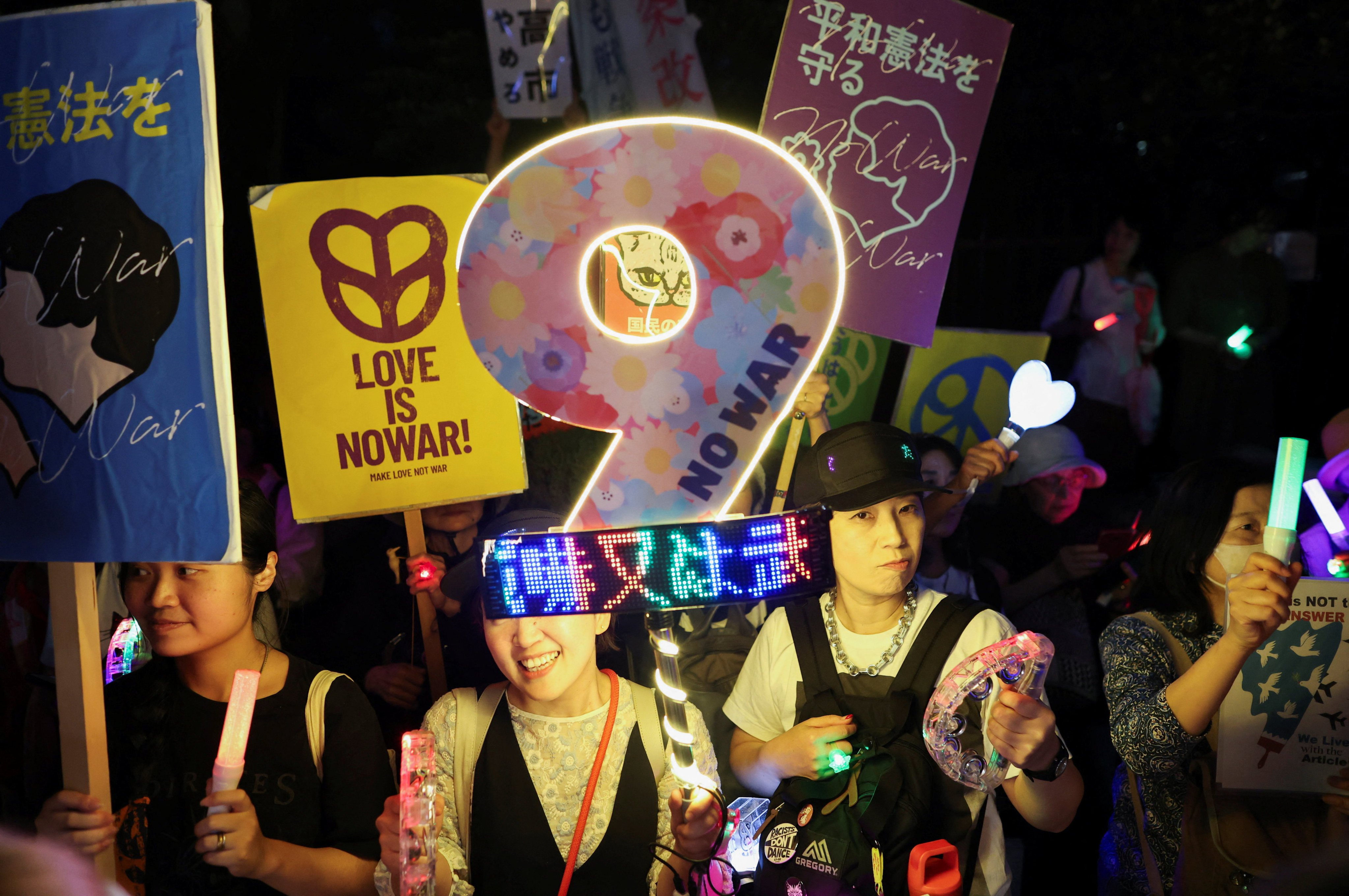 Protesters hold lights and a placard shaped like the number nine, referring to Article 9 of Japan’s constitution, which renounces war as a sovereign right and prohibits the maintenance of armed forces, during a rally against militarism, in Tokyo, Japan, on May 29. Photo: Reuters