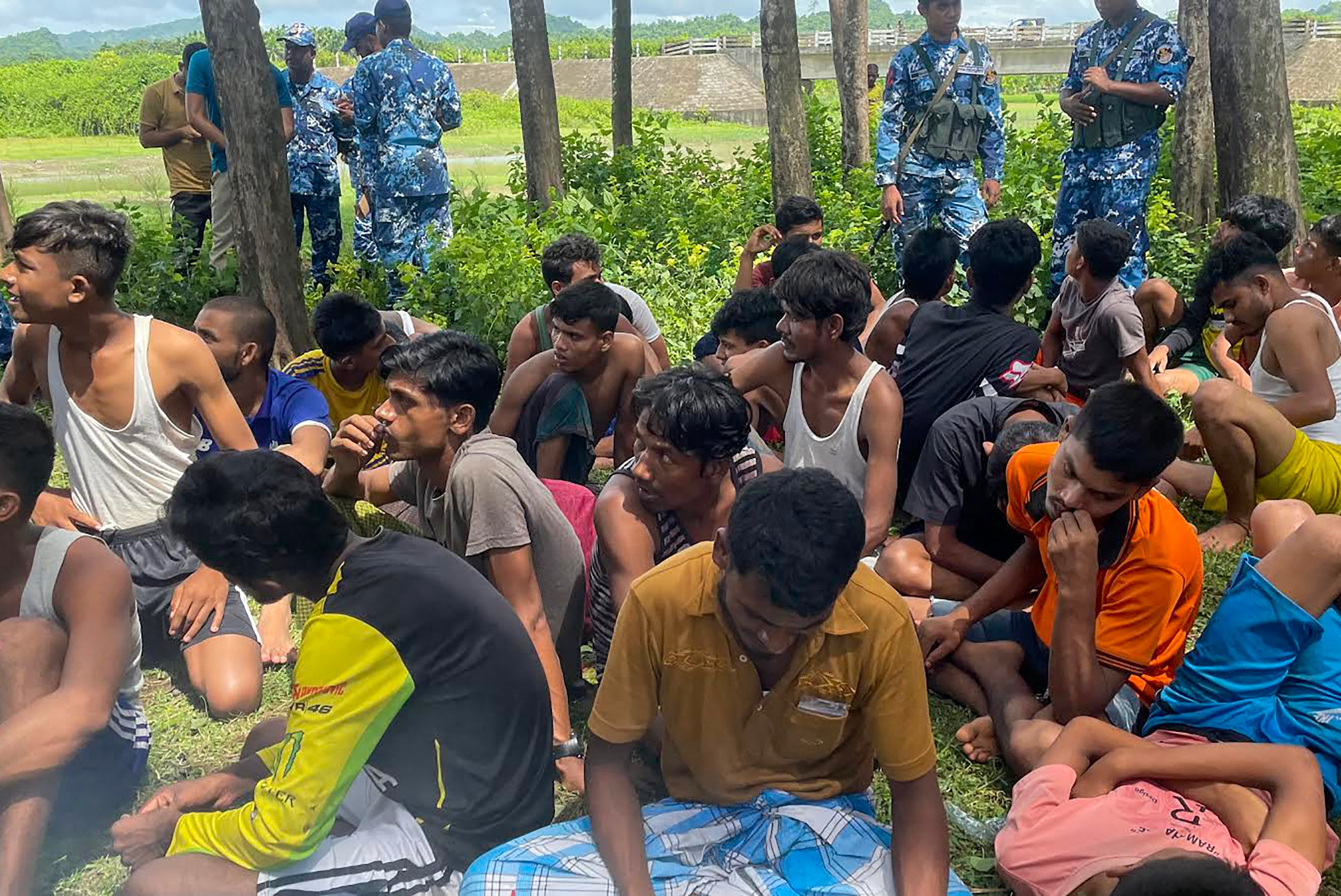 Bangladeshi security personnel stand guard beside Rohingya refugees rescued from a Malaysia-bound boat that sank off the coast of Teknaf in 2022. Photo: AFP