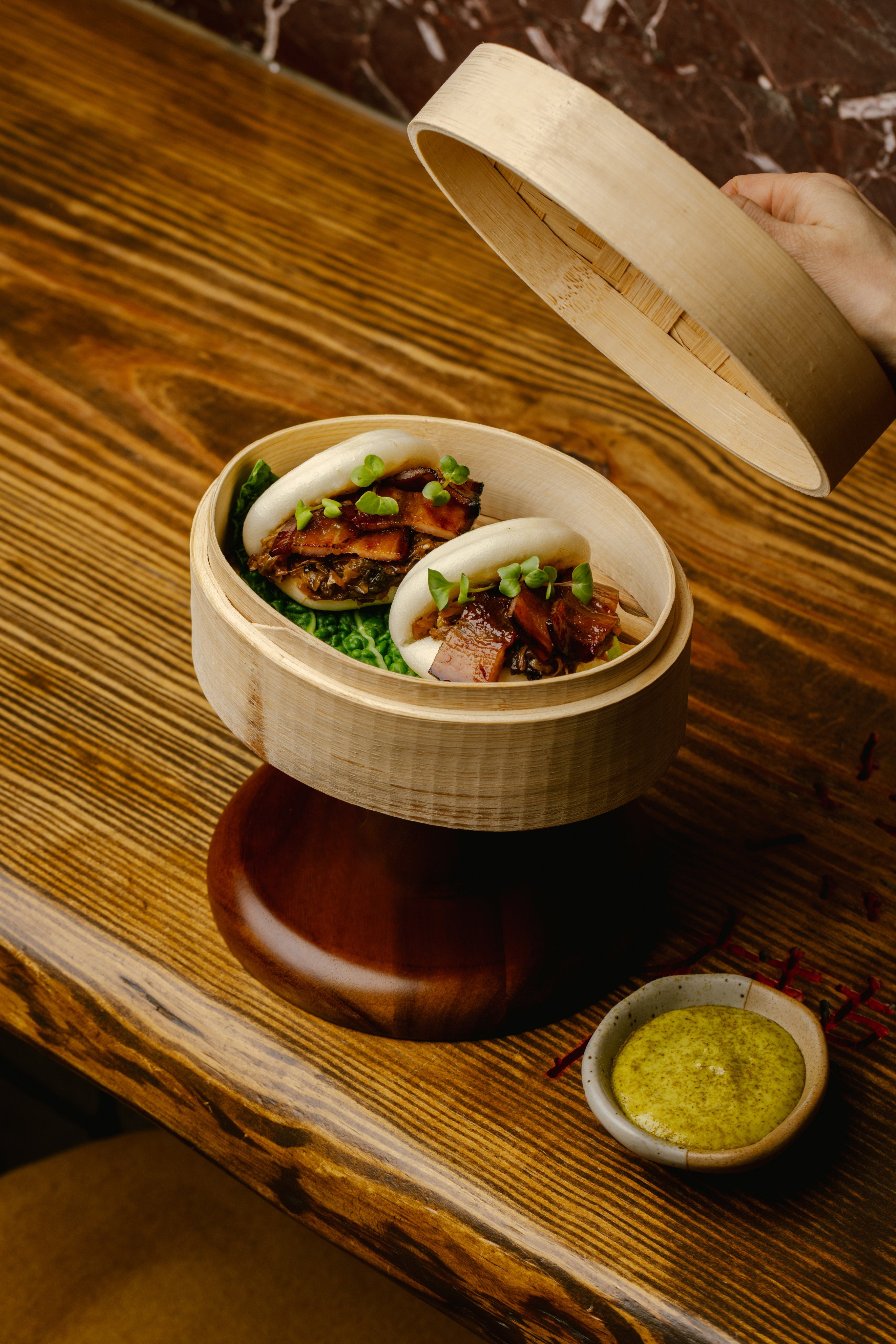 Pillowy steamed buns are filled with charcoal-grilled smoked pork belly and a classic Alsace choucroute. Photo: Racines
