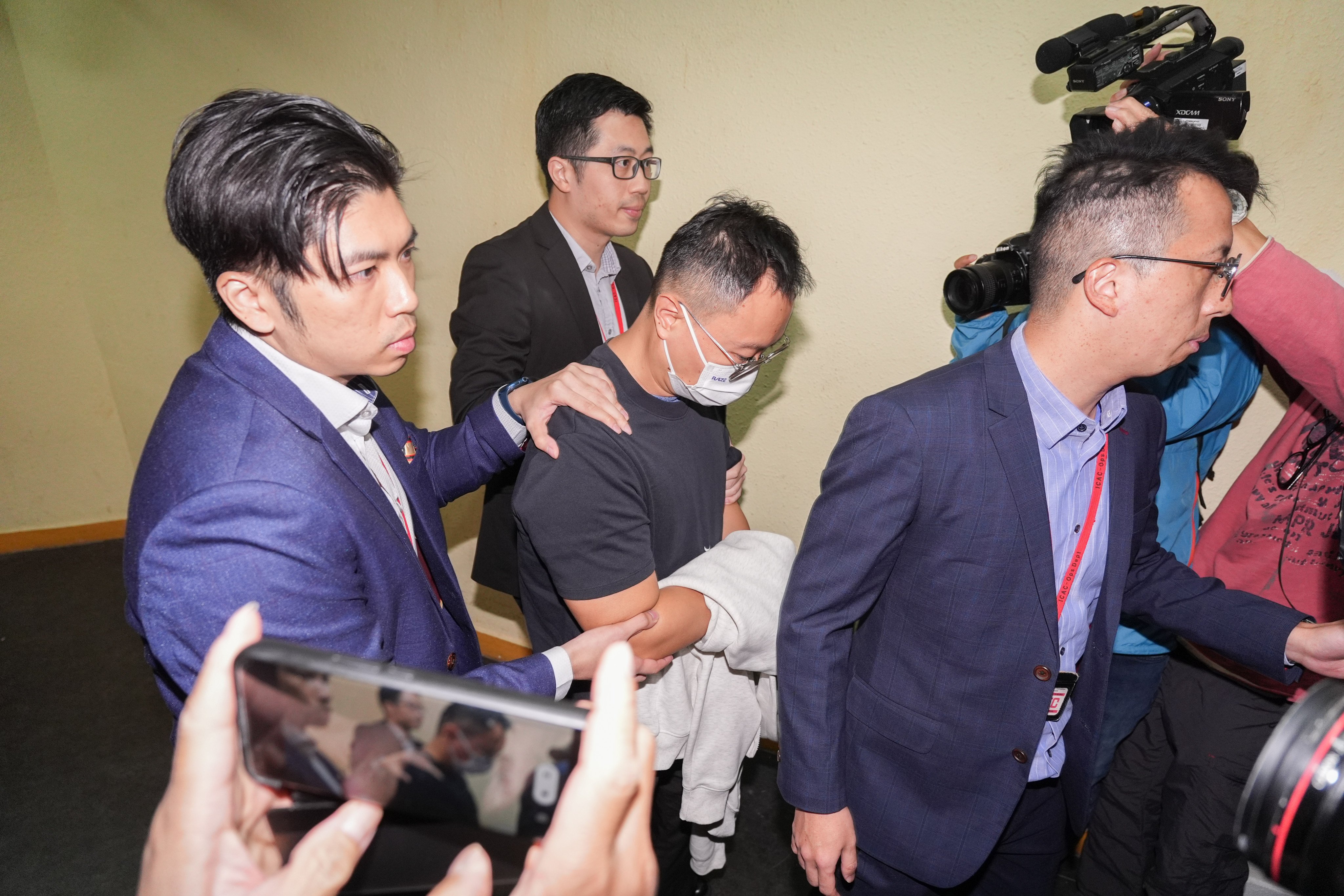 Investigators escort a suspect from Will Power Architects to the firm’s office following the Tai Po fire. Photo: Eugene Lee