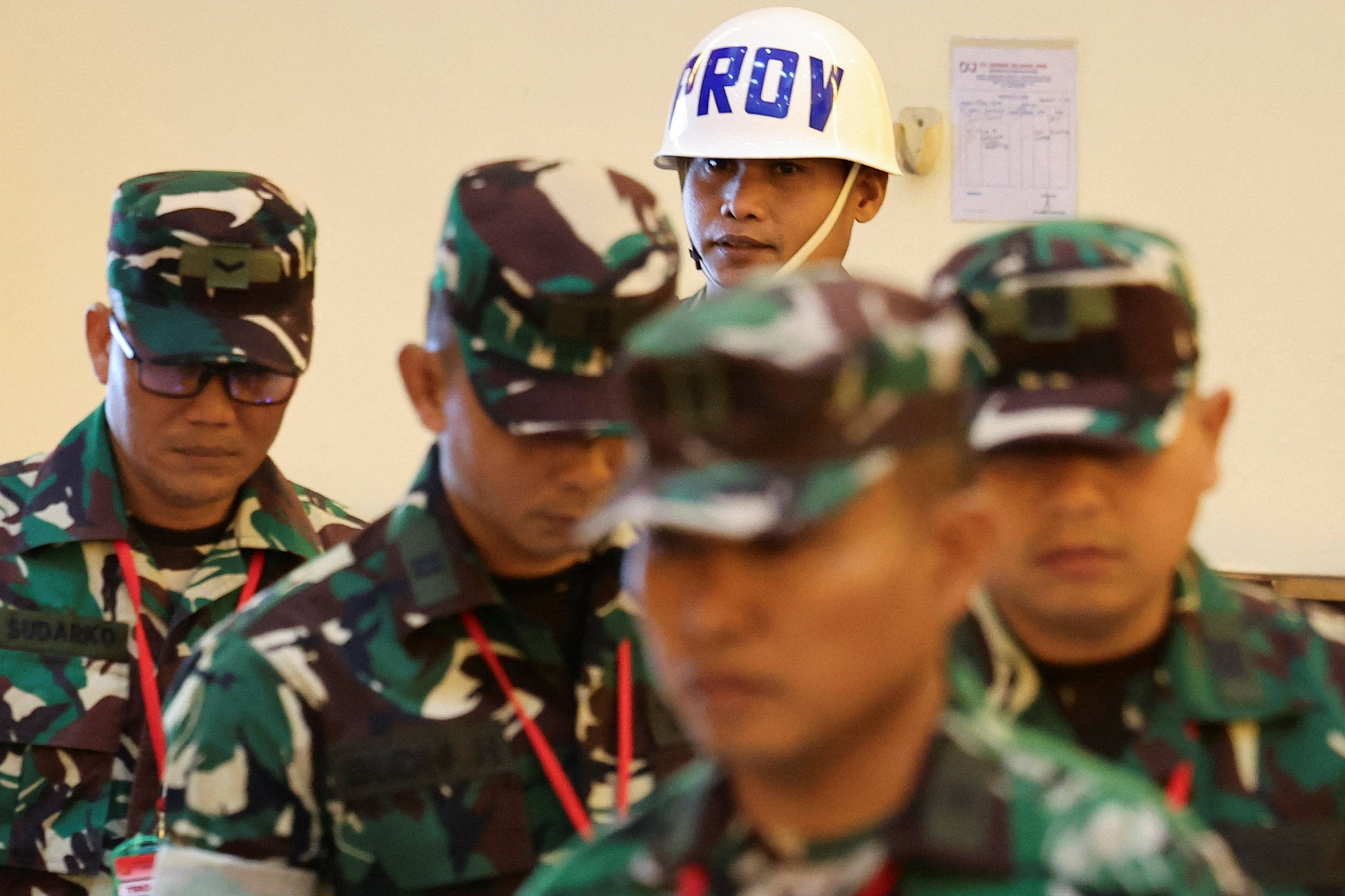 An Indonesian military police officer escorts military personnel charged over an acid attack on human rights activist Andrie Yunus into the courtroom on Wednesday. Photo: Reuters