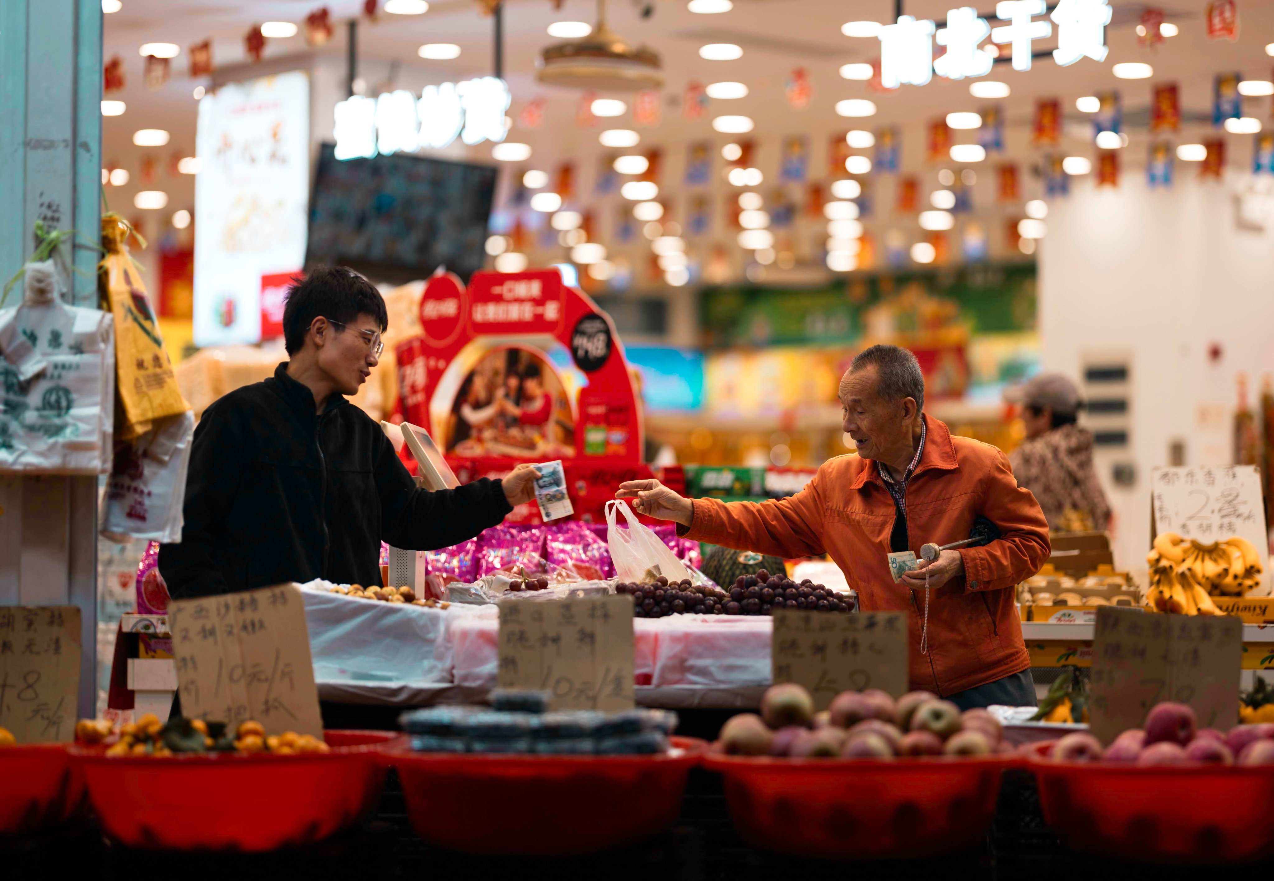 A man purchases groceries at a shop in Shanghai. Photo: EPA