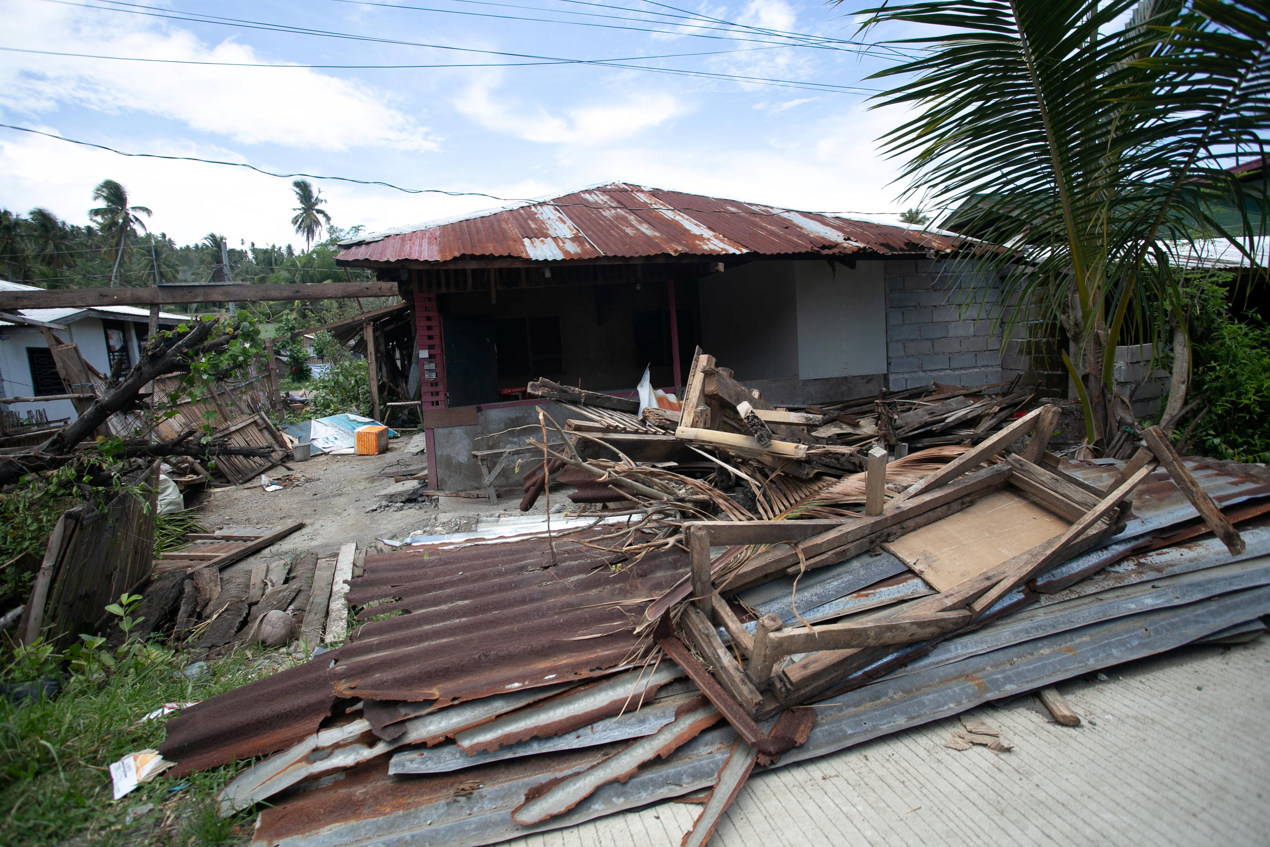 Debris from a damaged house in Glan is scattered along the road following Monday’s magnitude 7.8 quake. Photo: Reuters