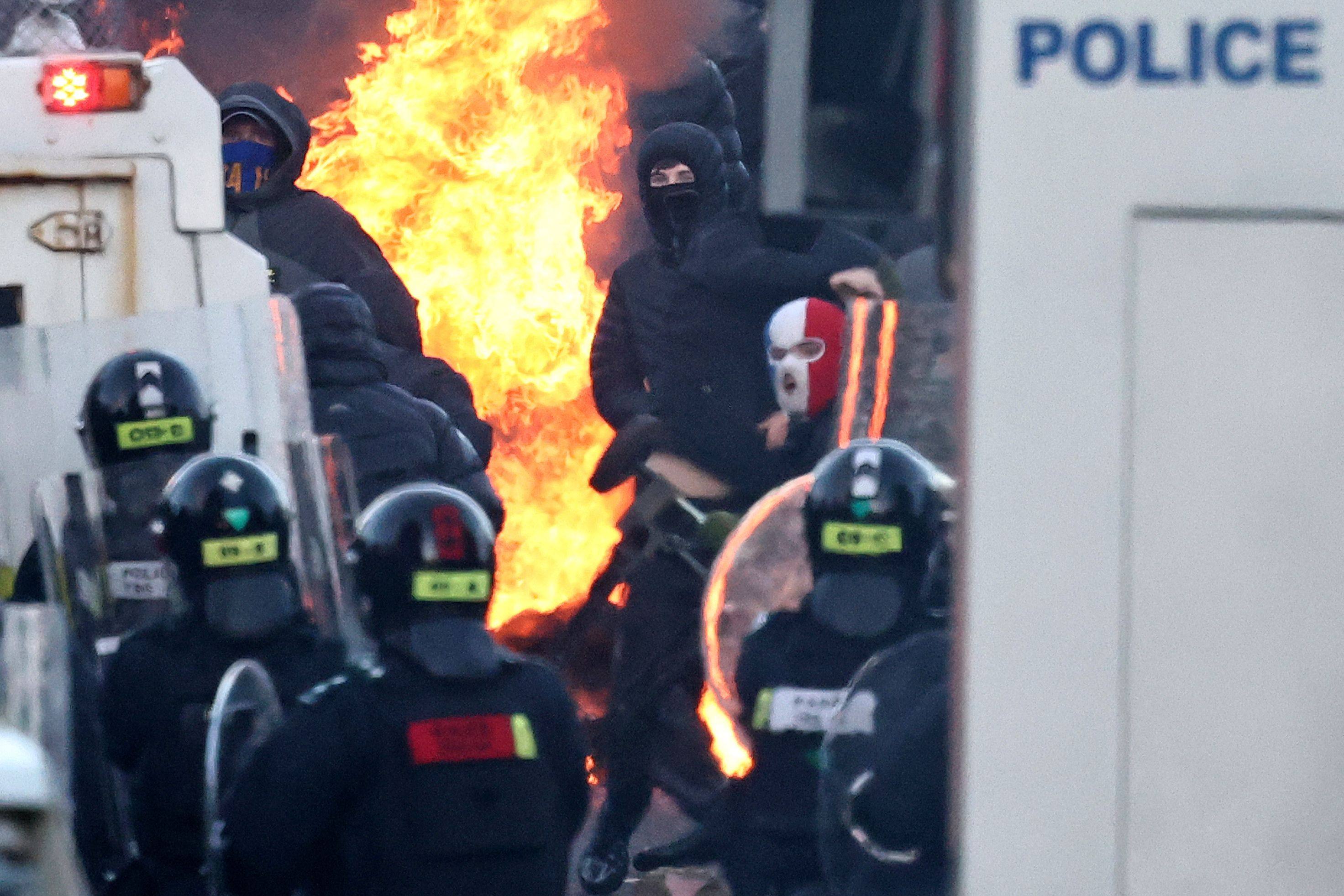 Masked rioters clash with police blocking their way to a hotel housing asylum seekers in Glengormley, north of Belfast, on Wednesday night. Photo: AFP